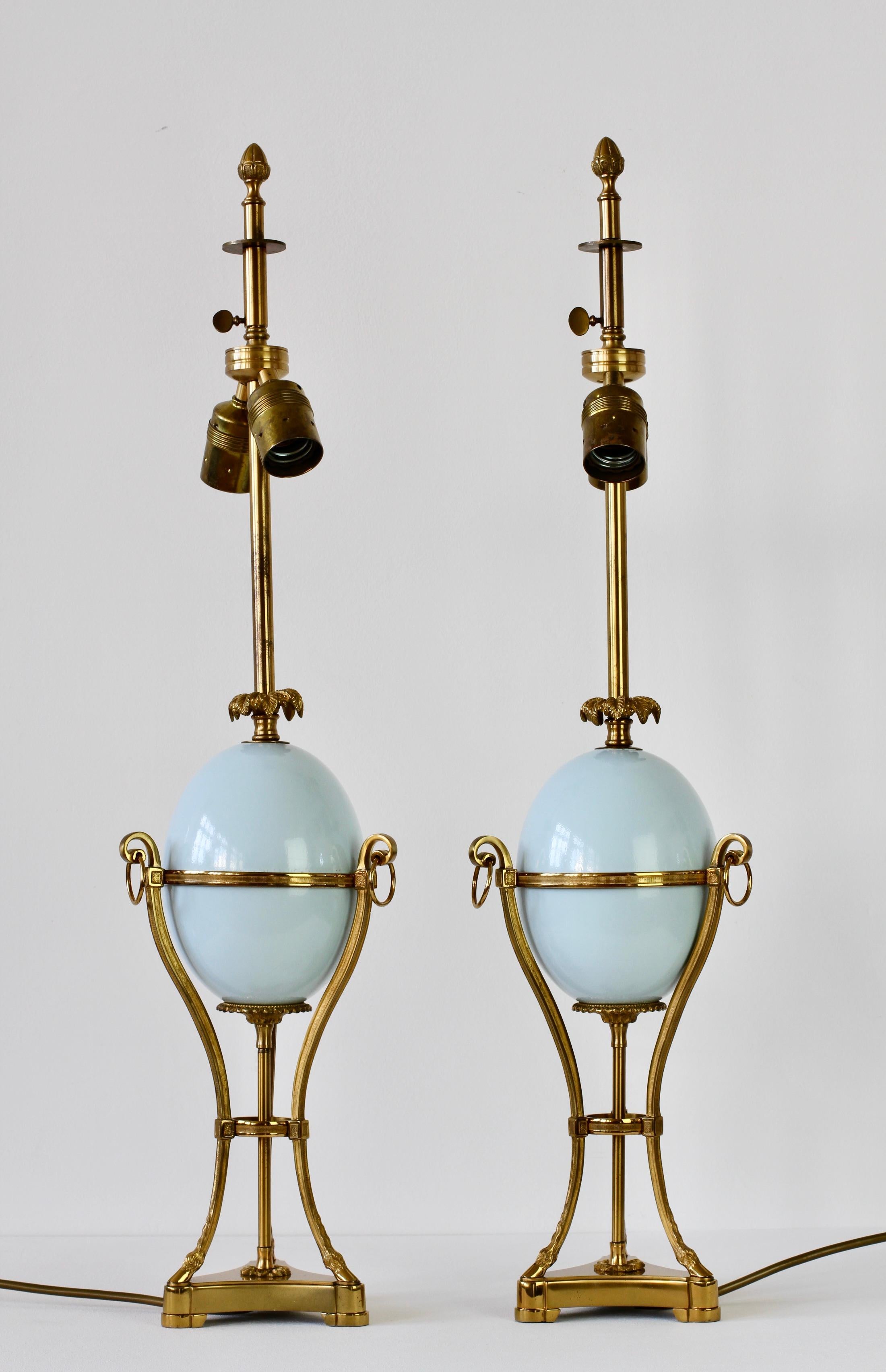 Maison Charles attributed midcentury vintage pair of French brass neoclassical lamps centred on ostrich eggs. Stunning craftsmanship with beautifully cast brass elements, the palm leaf details above the powder blue eggs, the acorn final on the
