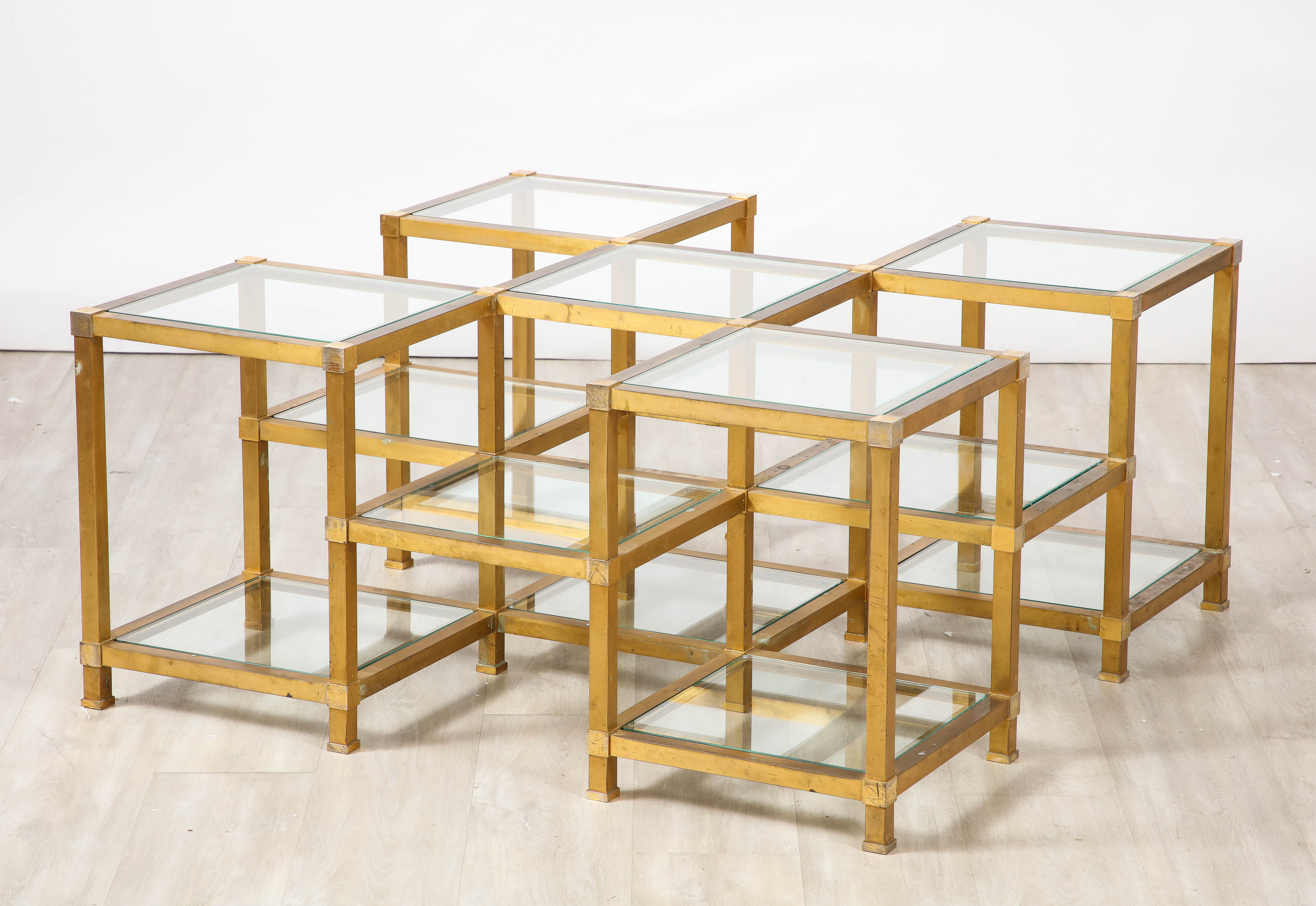 A brass and glass cocktail table by Maison Charles et Fils, Paris, circa 1970, the square brass grand frame comprising 5 square glass surfaces at the very top with an additional 8 glass surfaces in graduating levels.  The glass all original, with