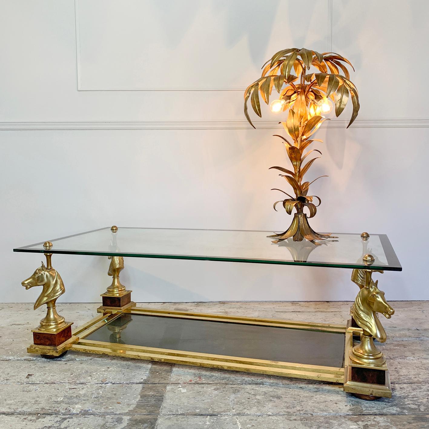 Midcentury French 'Cheval' horse coffee table
Maison Charles,
circa 1950s.
Brass horse heads on each corner supporting a black banded edge clear glass top
Underneath a double banded brass frame supports a further tinted glass shelf
Some