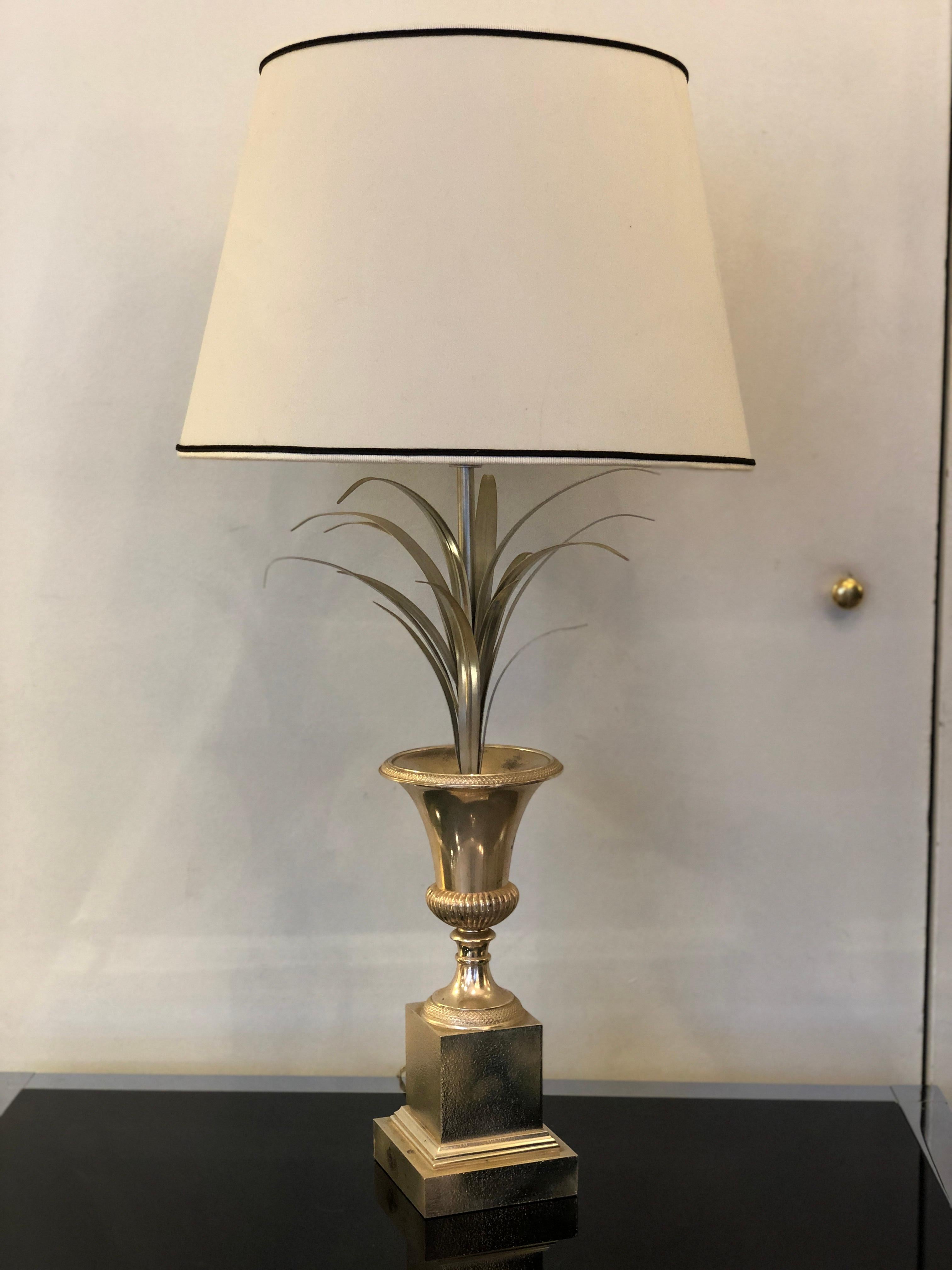Lampe de table Charles e Fils en métal argenté, vase à fleurs de palmier, fabriquée en France vers les années 1960.
La lampe, qui présente la forme typique d'un vase de fleurs, a été fabriquée par Charles et Fils en France dans les années