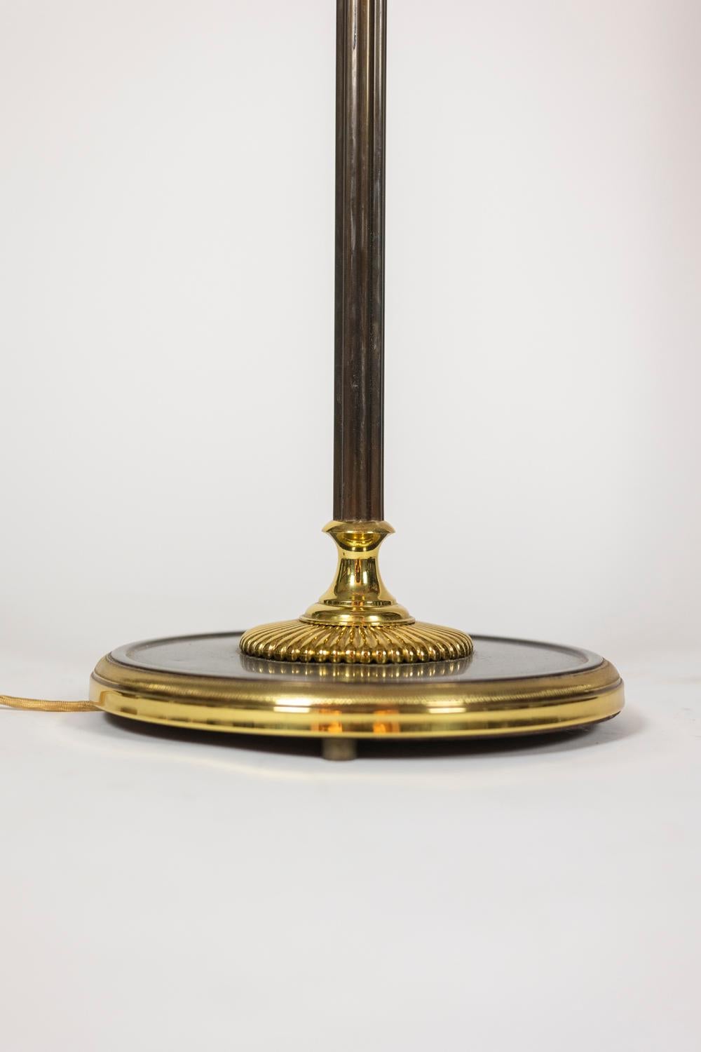 Maison Charles, by. 

Floor lamp, “Roseau” model in patinated bronze and gilded brass. Striated shaft decorated with a reed placed in its “Chambord” vase, ending in the upper part with a stylized acorn. Circular base decorated with a gadroon.