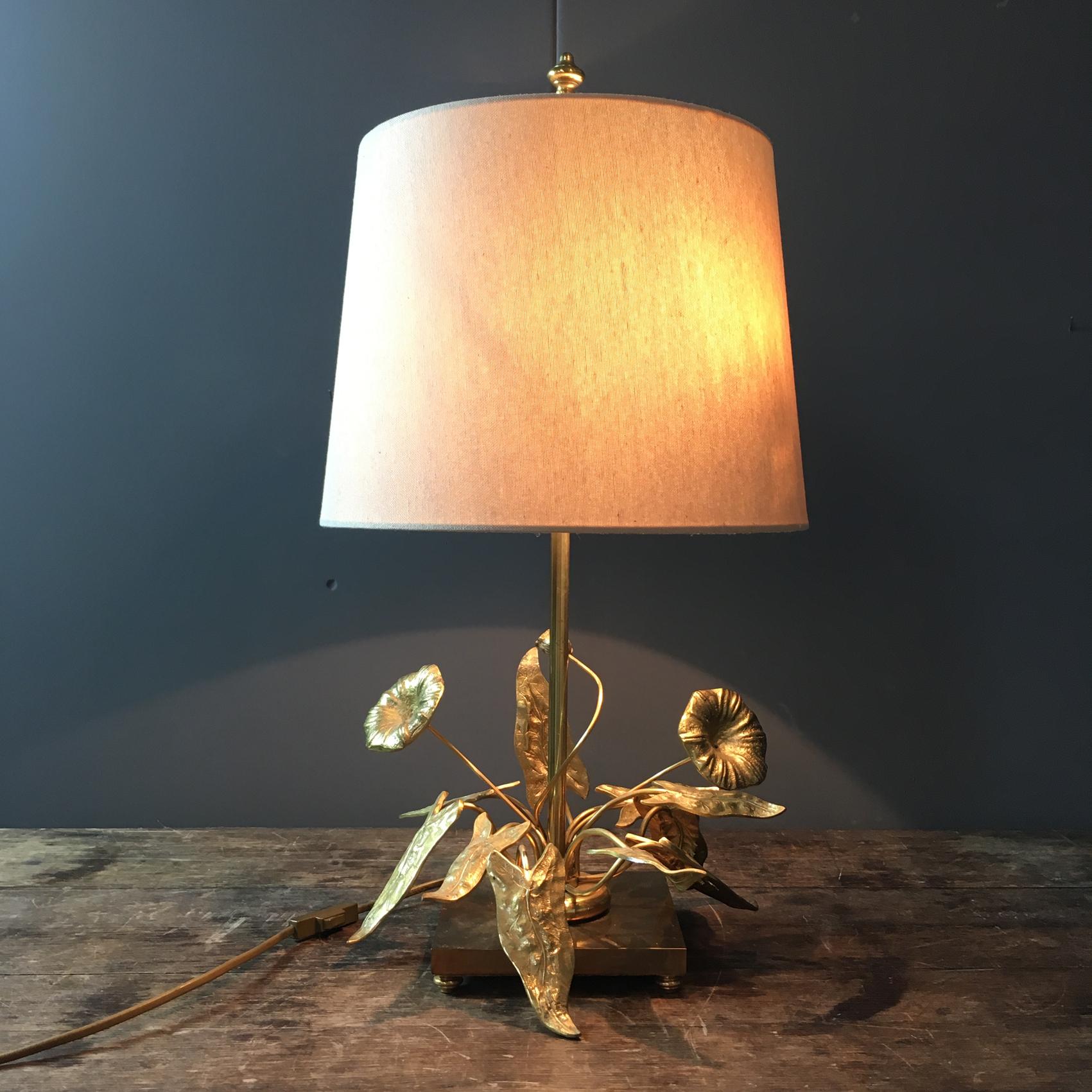 Elegant table lamp from Maison Charles in bronze and gilded brass decorated with flowers and foliage, all placed on a square base.

circa 1960s

The shade is a modern replacement

The lead has the original gold rocker switch

The light