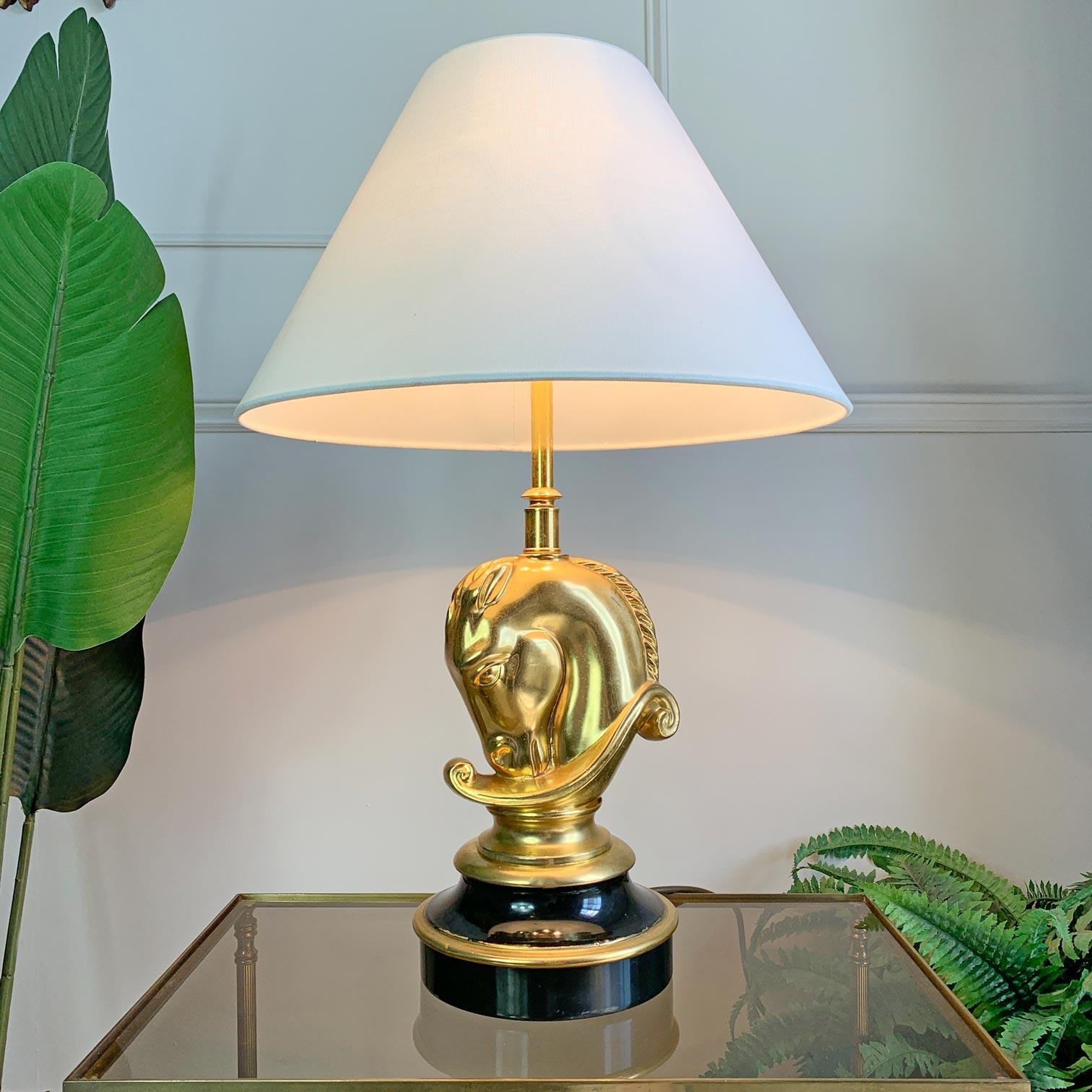 Table lamp in the form of a classical horse head in 24k gold plated brass upon an ebonised base with gilt detail, made by Deknudt circa 1970. In super condition, some time related wearing to the gilt band, it takes 3 e14 (small screw in bulbs).