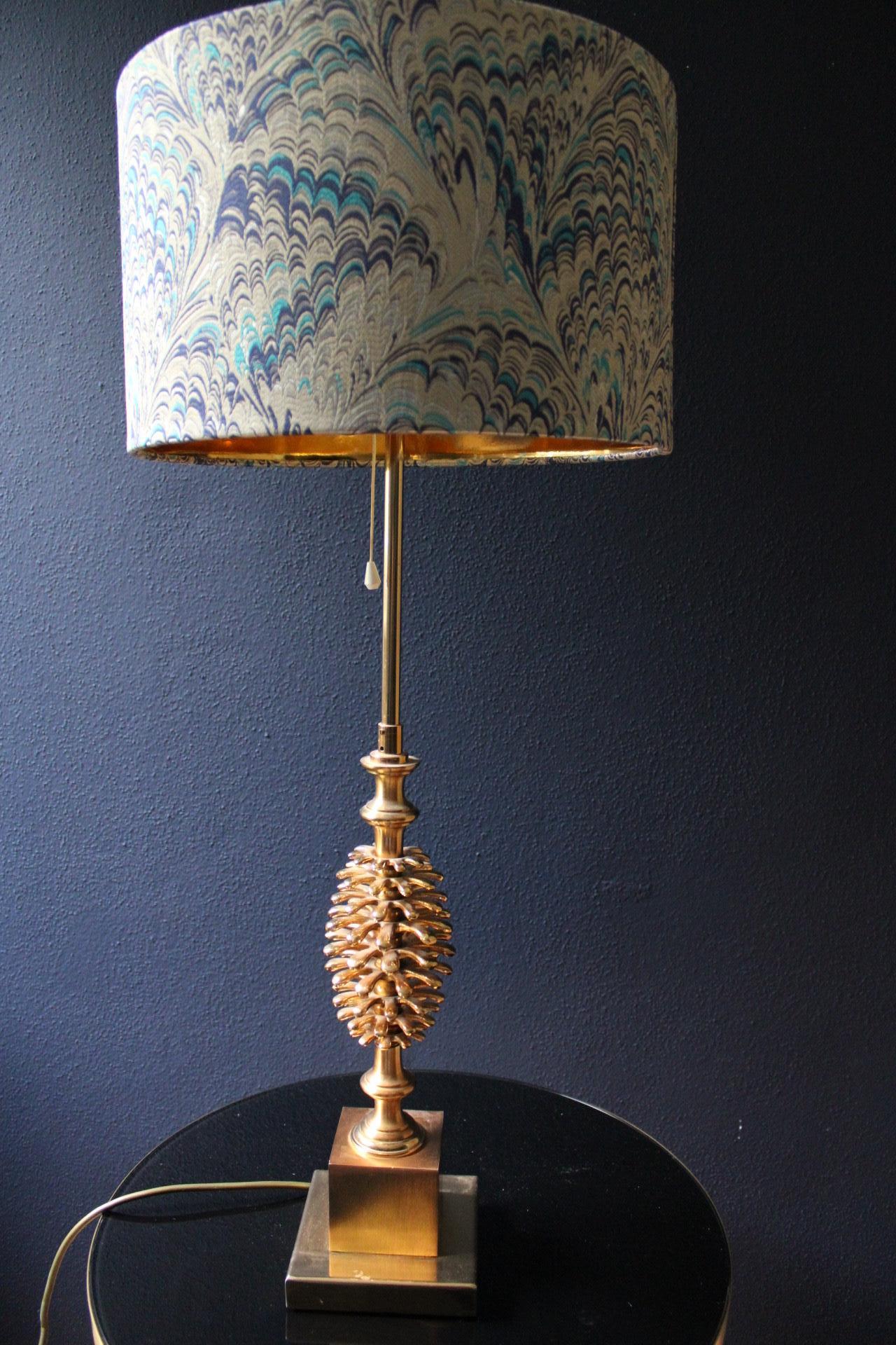 This gleaming pinecone table lamp in a superb condition and fully functional!

A true Hollywood Regency statement piece, the rather heavy and tiered base is made of gold-plated metal with no loss of the gold altogether!

While no makers mark visible