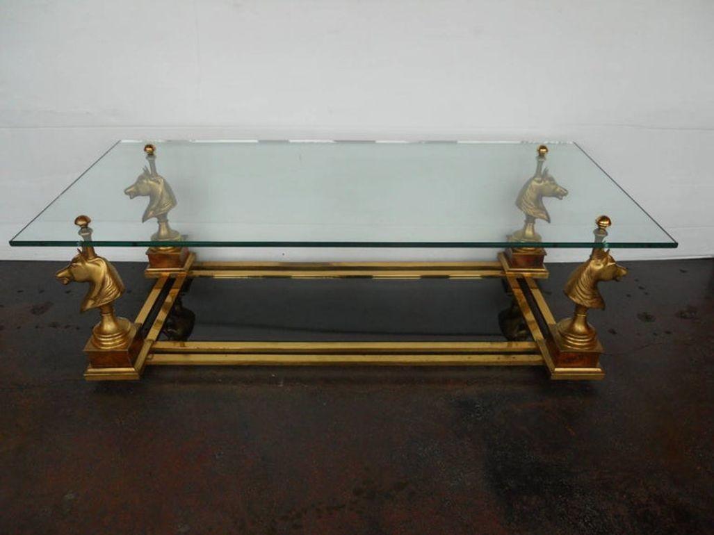 Playful and elegant Maison Charles coffee table, featuring four sculptural gilt bronze horse head figures supporting a rectangular glass top. The design balances whimsical detail with refined craftsmanship, a hallmark of the Maison Charles