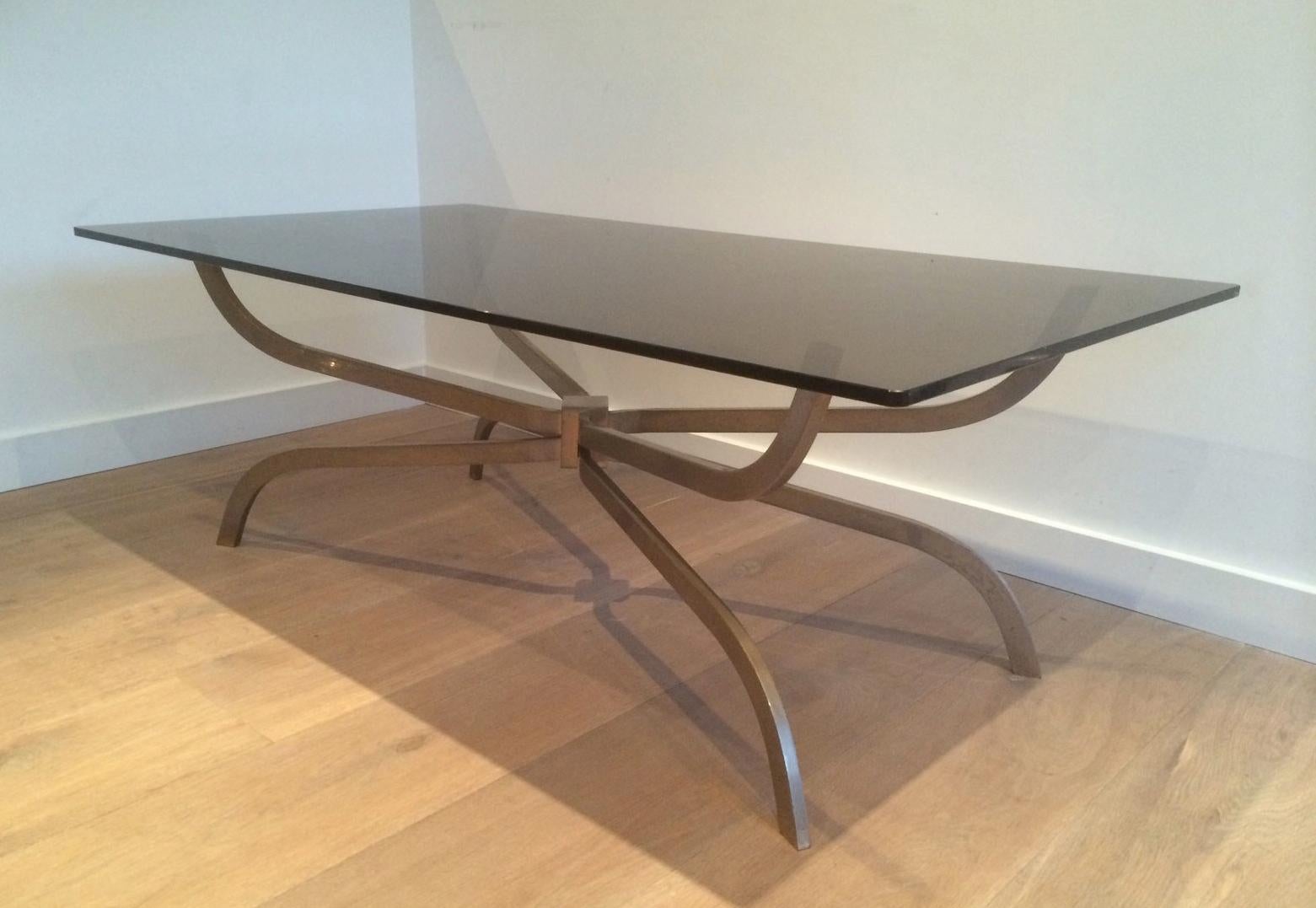 This interesting coffee table is made of brushed steel with a smoked glass top. This is a model by famous French designer Maison Charles. The quality is very good, circa 1960.