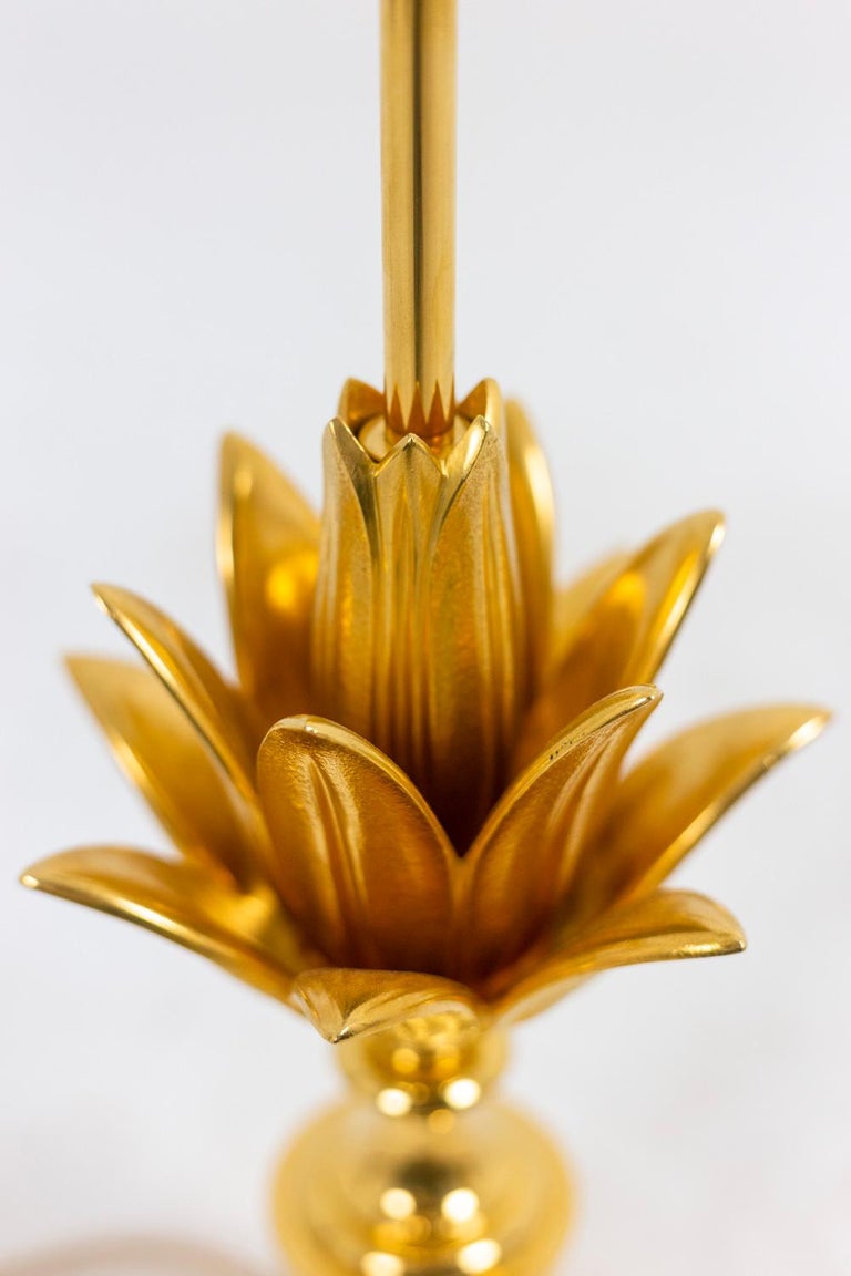 Maison Charles, edited by. 

Lamp in gilt bronze with stylized lotus decoration on a square base. Original patinated brass shade ending in a pine cone.

French work realized in the 1960s.