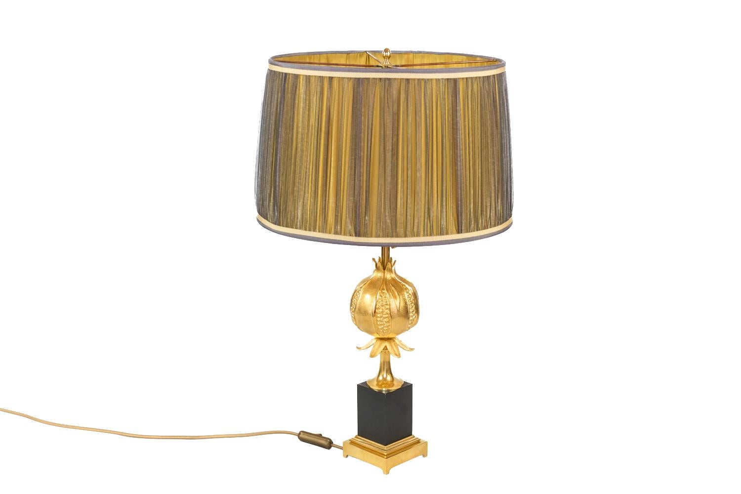 Pomegranate lamp in gilt bronze standing on a square moulded base in gilt bronze, topped by a cubic black bakelite pedestal. Shaft with a tulip base shape topped by a grenade opened in some areas.
Work of Maison Charles realized in the