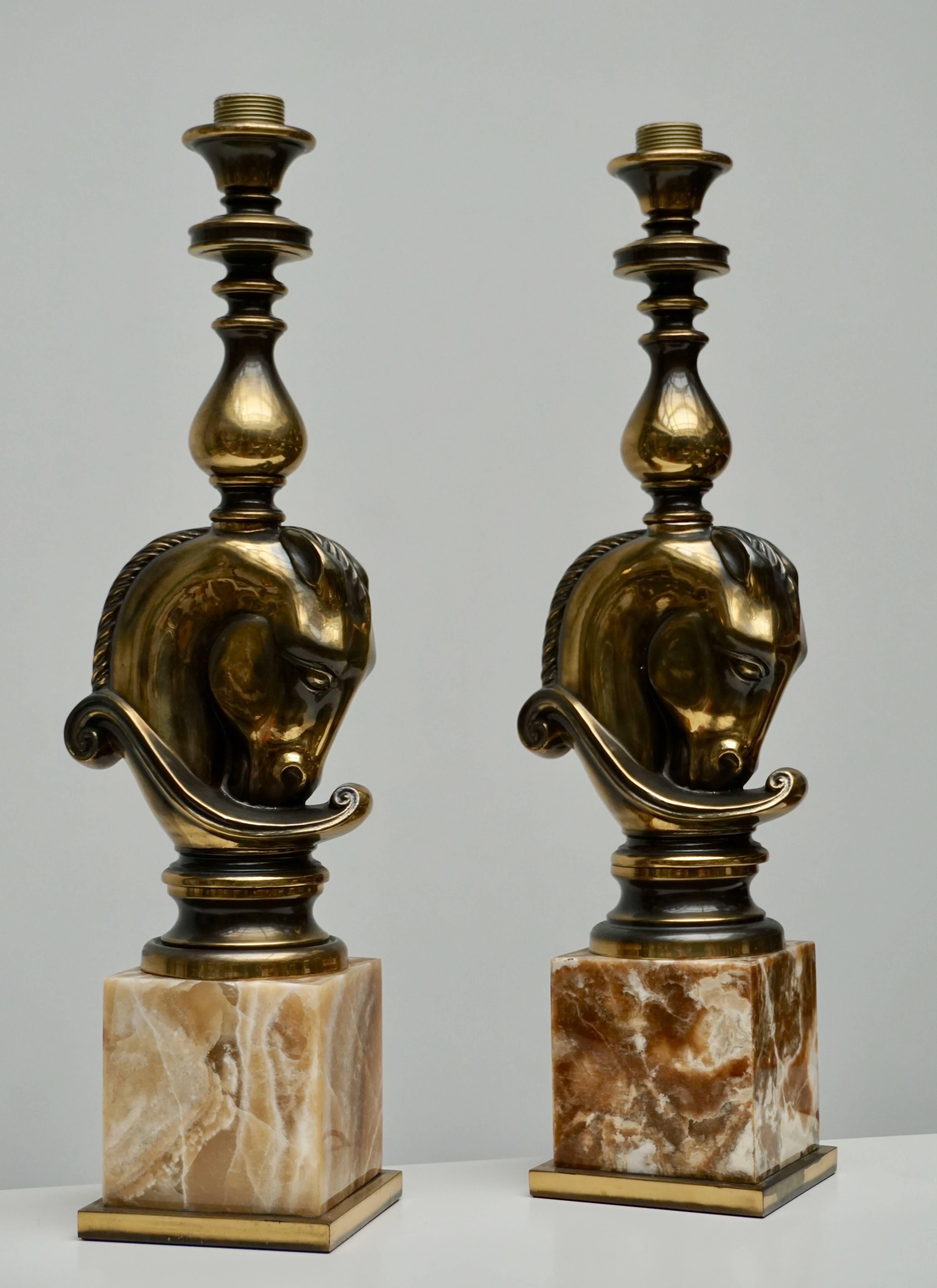 Pair of large brass table or floor lamps in brass and onyx marble by Maison Charles.
The horse heads are made of brass and are rested on two onyx marble bases.
The shades are not included.