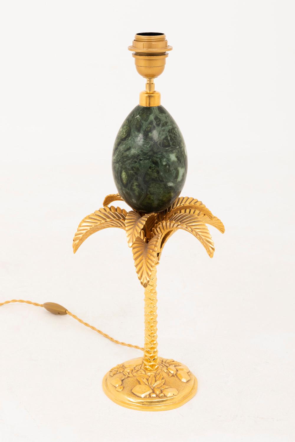 Maison Charles, in the style of.
Palm tree lamp with a shaft in green marble egg shape standing on palm tree in chiselled and gilt bronze.
Circular base in gilt bronze with a guilloche background and relief decor of stones and leaves.

Circular
