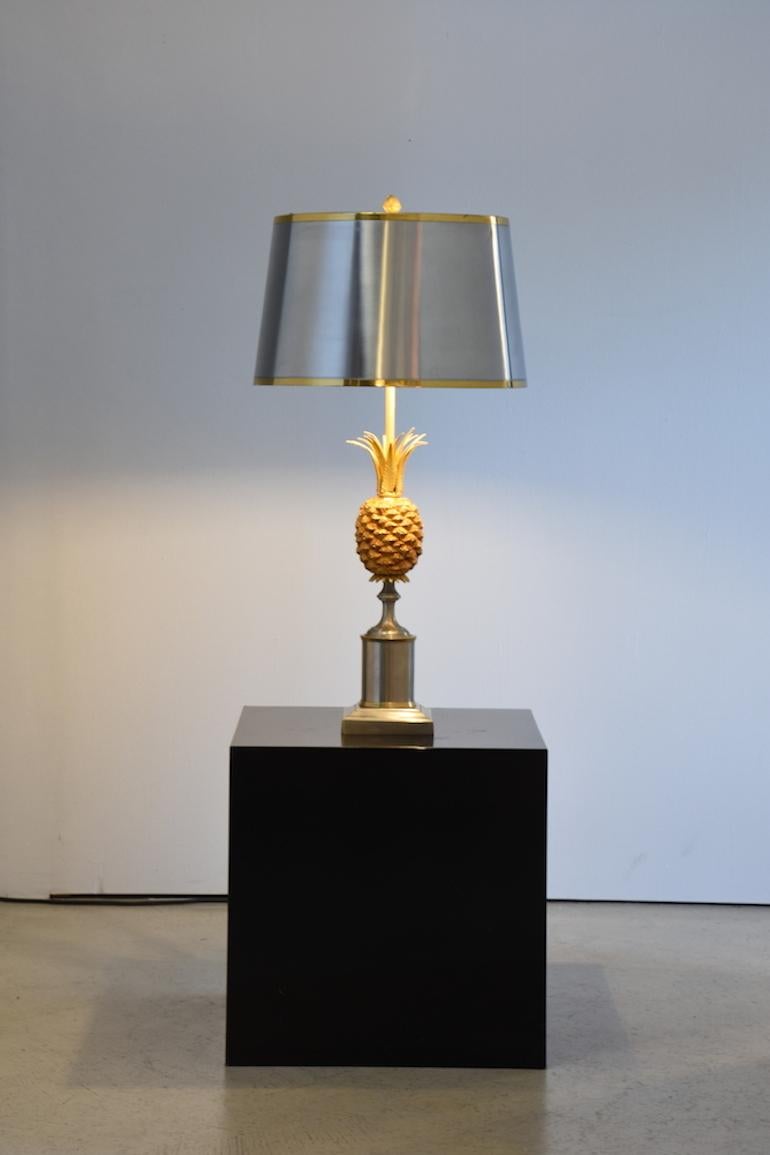 A pair of Maison Charles pineapple table lamps, designed 1960s for Maison Charles, Paris with finely carved pineapple sculptures. Brass and copper coated metal, metal screen. 
Slightly cylindrical lampshade topped by a pinecone. Pattina visible on