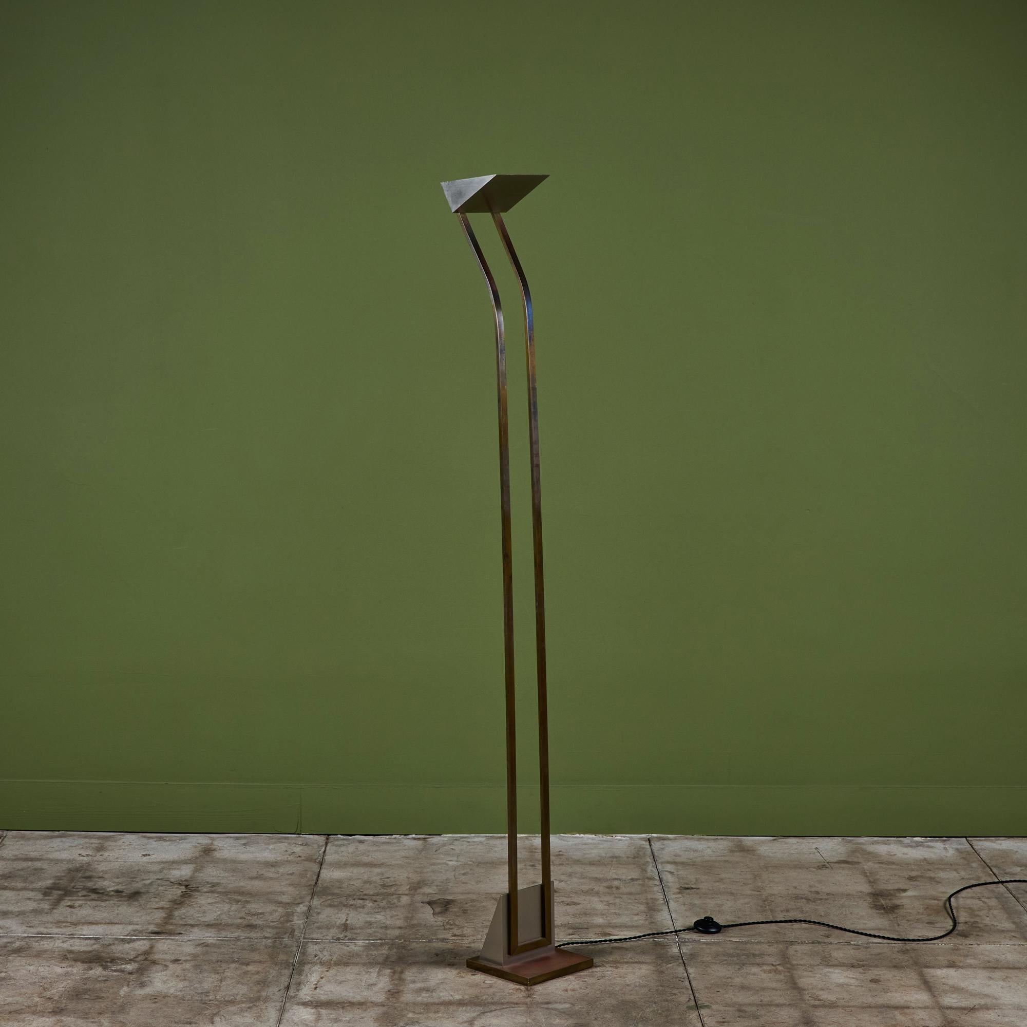 Postmodern torchiere floor lamp for Maison Charles, c.1980s, France. The lamp features a slim simplistic brass stem with a stainless steel uplight shade. The lamp rests on a stainless steel and brass base that mimics the top of the lamp. Newly