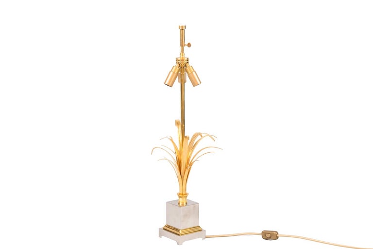 Maison Charles, attributed to.
“Reeds” lamp in gilt and silvered bronze. Shaft figuring reeds planted in a small planter decorated with gadroons. Silvered cubic base, framed by gilt moldings and standing on a quadripode square shape base.
Circular