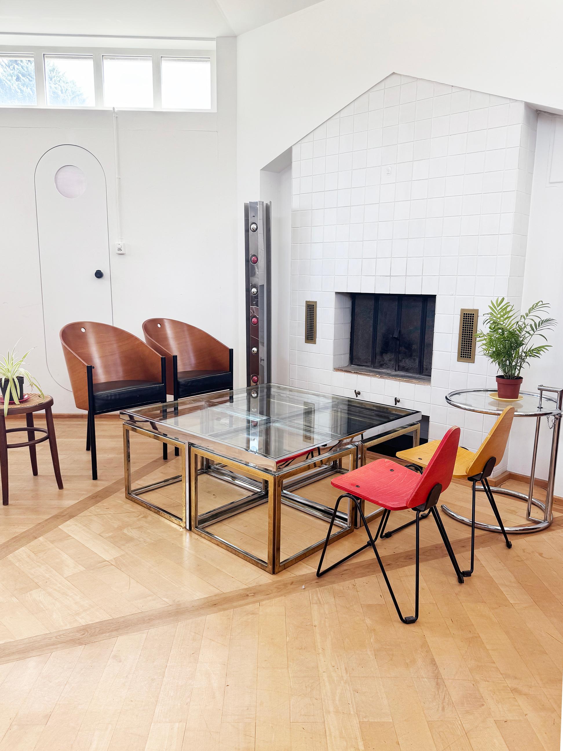 A striking large bicolor brass and chrome coffee, center, or cocktail table featuring four pull-out nesting side tables, circa 1970s. This design closely echoes the refined aesthetic of leading French design houses such as Maison Charles and Maison