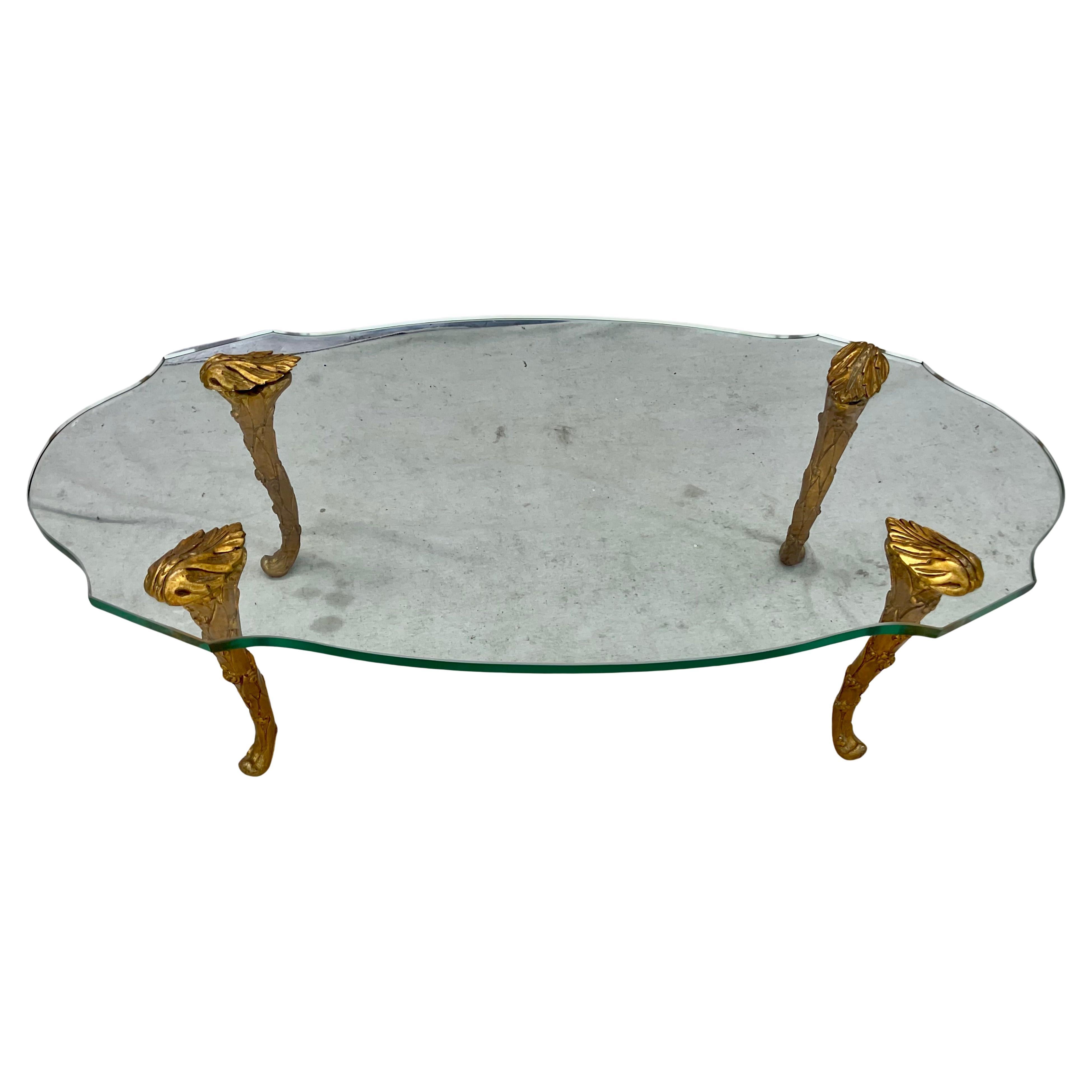 Dieser elegante und raffinierte Couchtisch im seltenen Maison-Charles-Design hat eine dicke Glasplatte, die auf schönen Akanthusbeinen aus vergoldetem Holz steht. Die Beine sind kunstvoll und fließend, mit feiner Schnitzerei, die die natürlichen