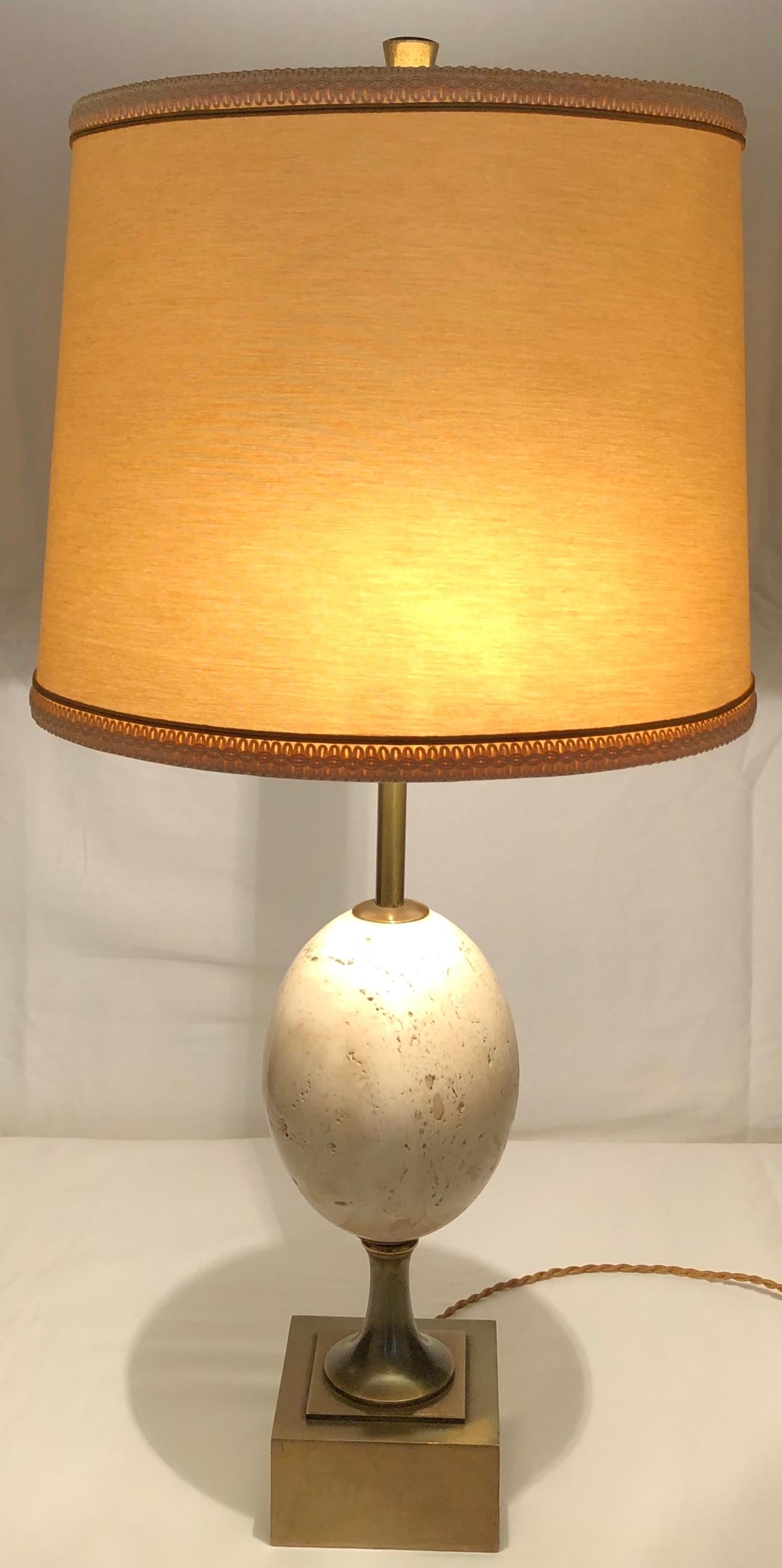 Original Maison Charles table or console lamp with egg shaped travertine center on brass base and new ivory colored shade. This is a signature piece from the well respected establishment. Very elegant appearance. 
Bears the makers mark.

The lamp is