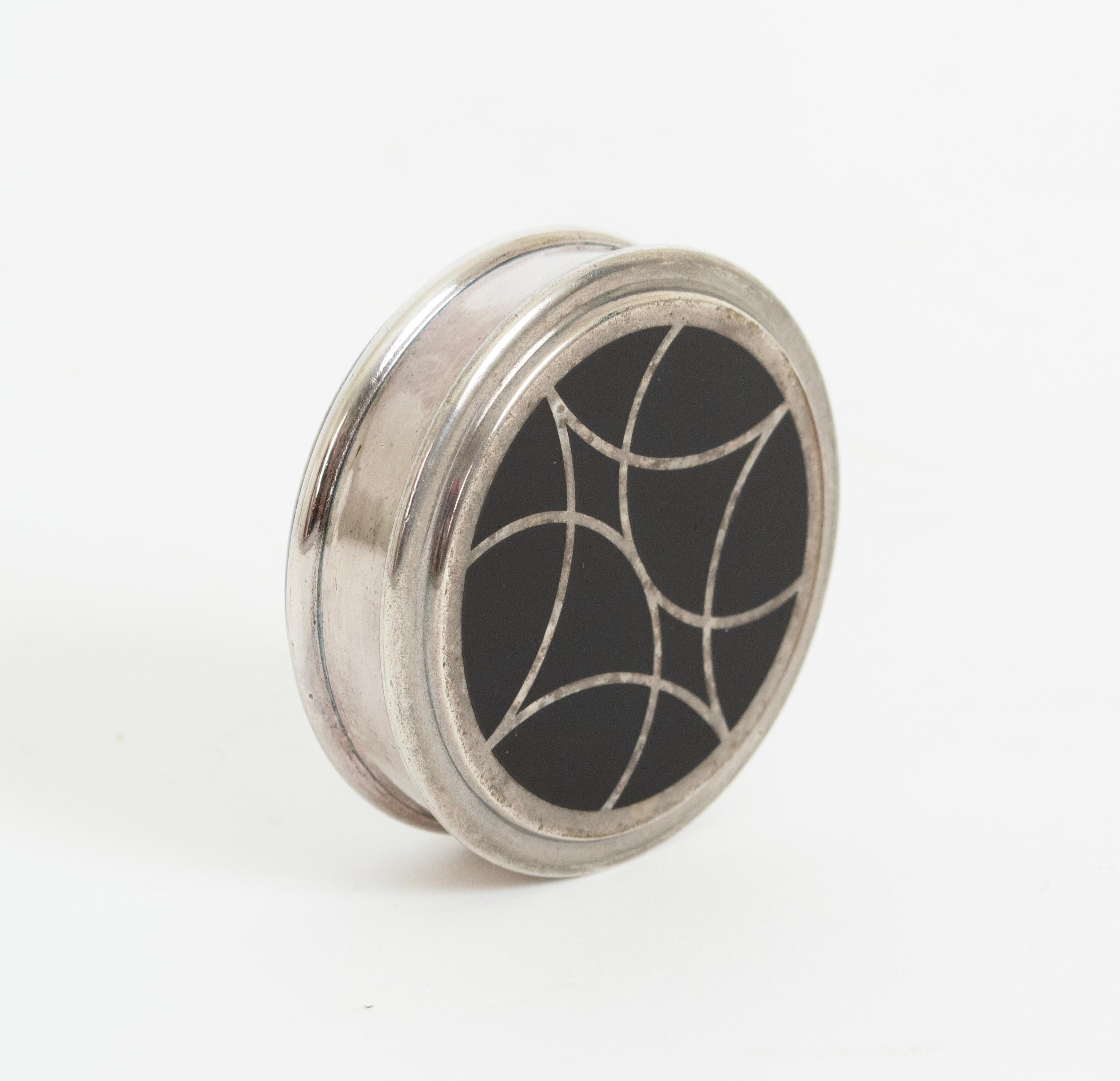 Diseñada por Bernard Yot en 1986, esta caja de baratijas presenta el raro motivo Talismán, de inspiración Art Déco. El llamativo diseño de Cloisonné es el resultado de un minucioso proceso de 22 pasos de estampado, lijado, lacado, barnizado,