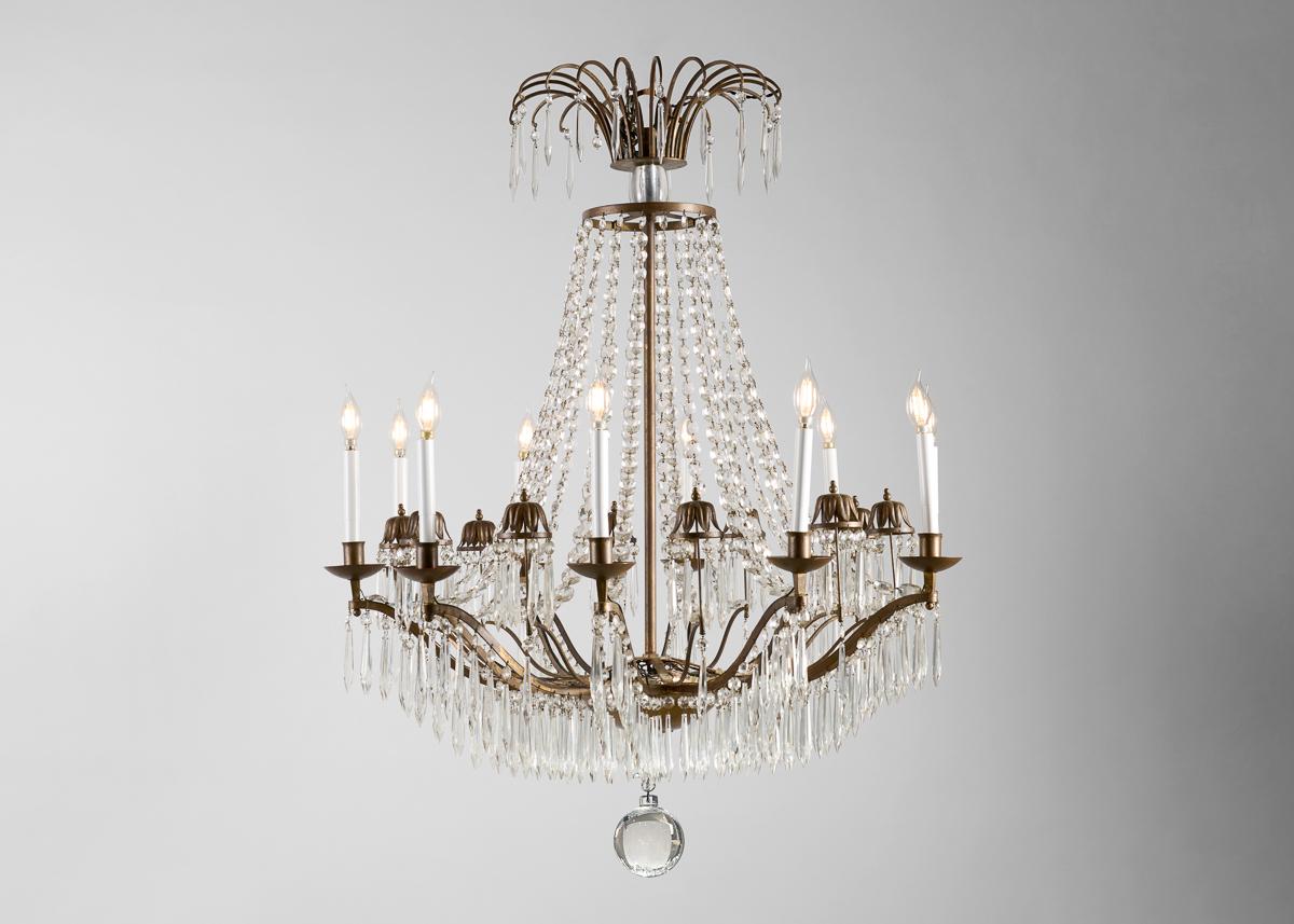 Each arm of this extraordinary chandelier is attached to the canopy with a string of crystals and festooned along its length with many more. The work's canopy, in turn, is itself a mirrored, albeit attenuated, image of these arms, an arrangement of