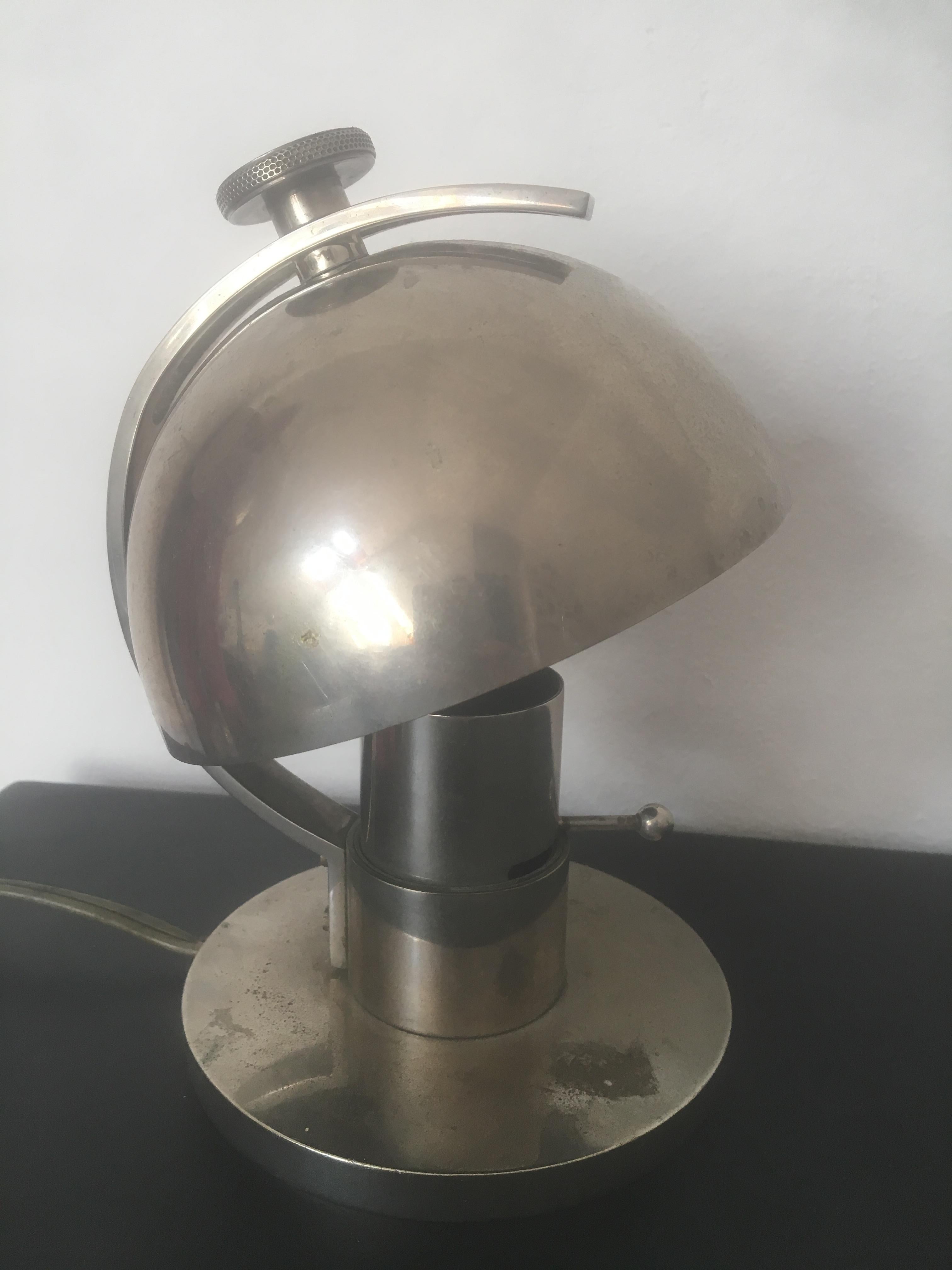 An Art Deco nickeled metal table lamp designed by Maison Desny in France in 1930s. A very modernist design with its adjustable metal lampshade and a bar as an on/off switch.
It comes from an important Art Deco lighting collection and has not been