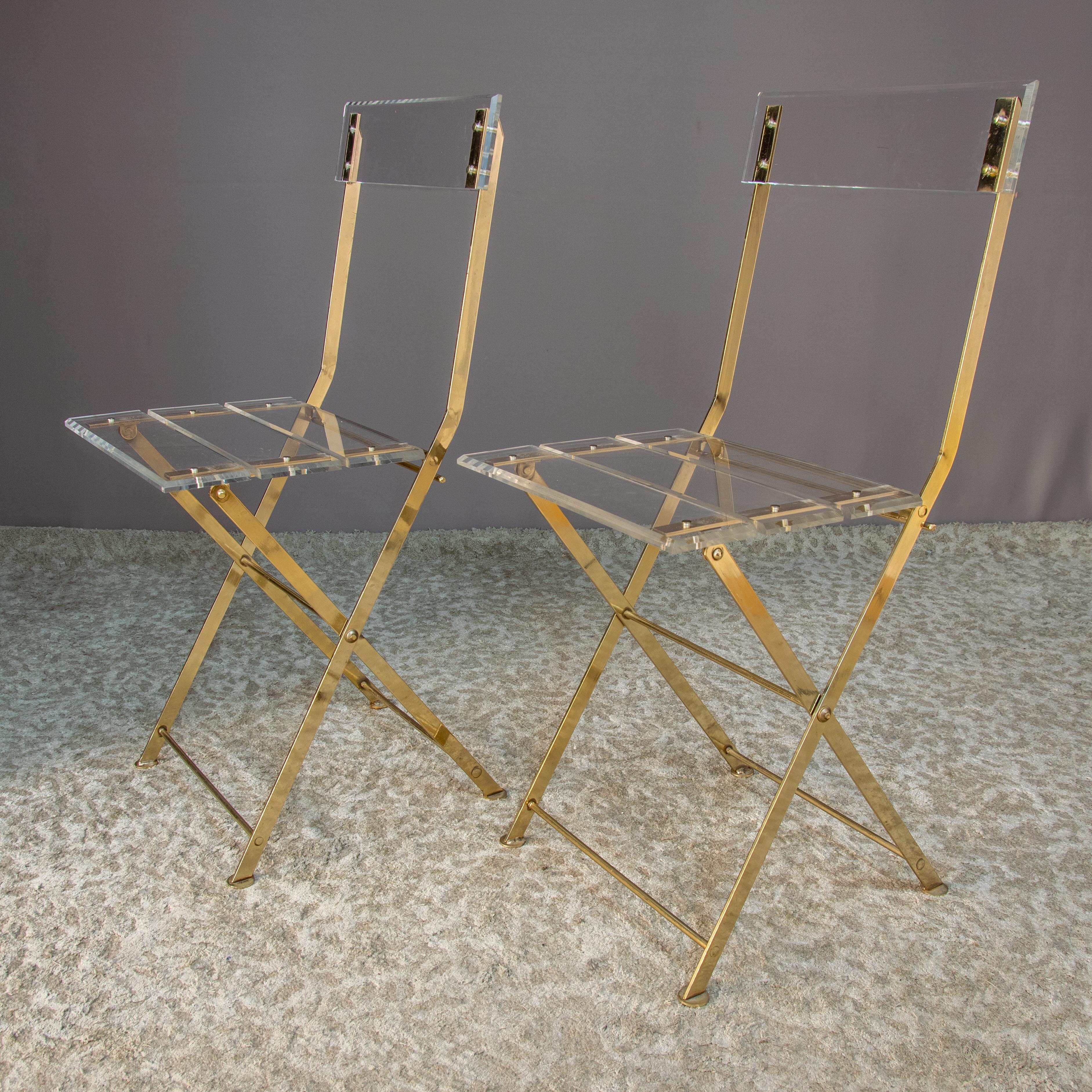 Stunning set of 2 garden style folding chairs in gilt brass and Lucite.

Only minor scuffs and imperfections on these chairs.