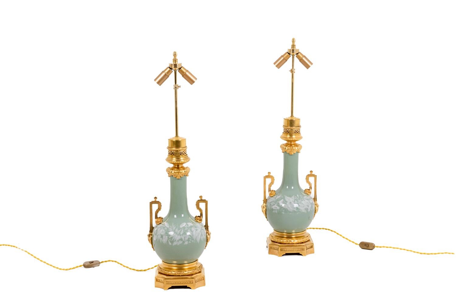 Maison Gagneau, signed.

Pair of lamps in celadon porcelain baluster-shaped. Panse adorned with garlands of bindweed in white enamel on a celadon background. Openwork handles adorned with acanthus leaves and rosettes. Frame in chiseled and gilded