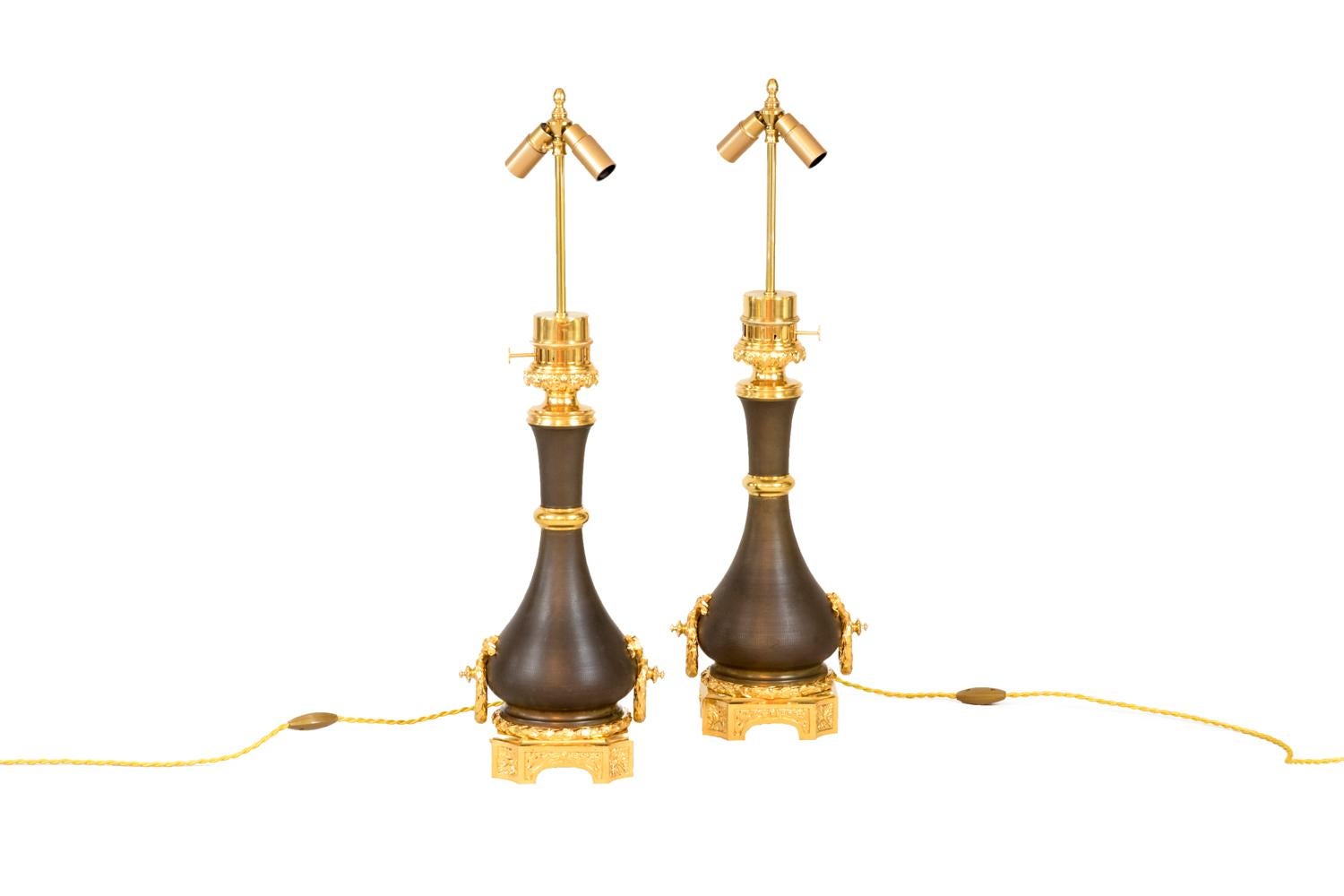 Maison Gagneau, signed.
Pair of baluster shape Louis XVI style lamps in guilloche brown brass.
Chiselled and gilt bronze mount. High of the mount with a decor of shells and cables frieze. Ring on the neck. Handles on each side of the lamp in