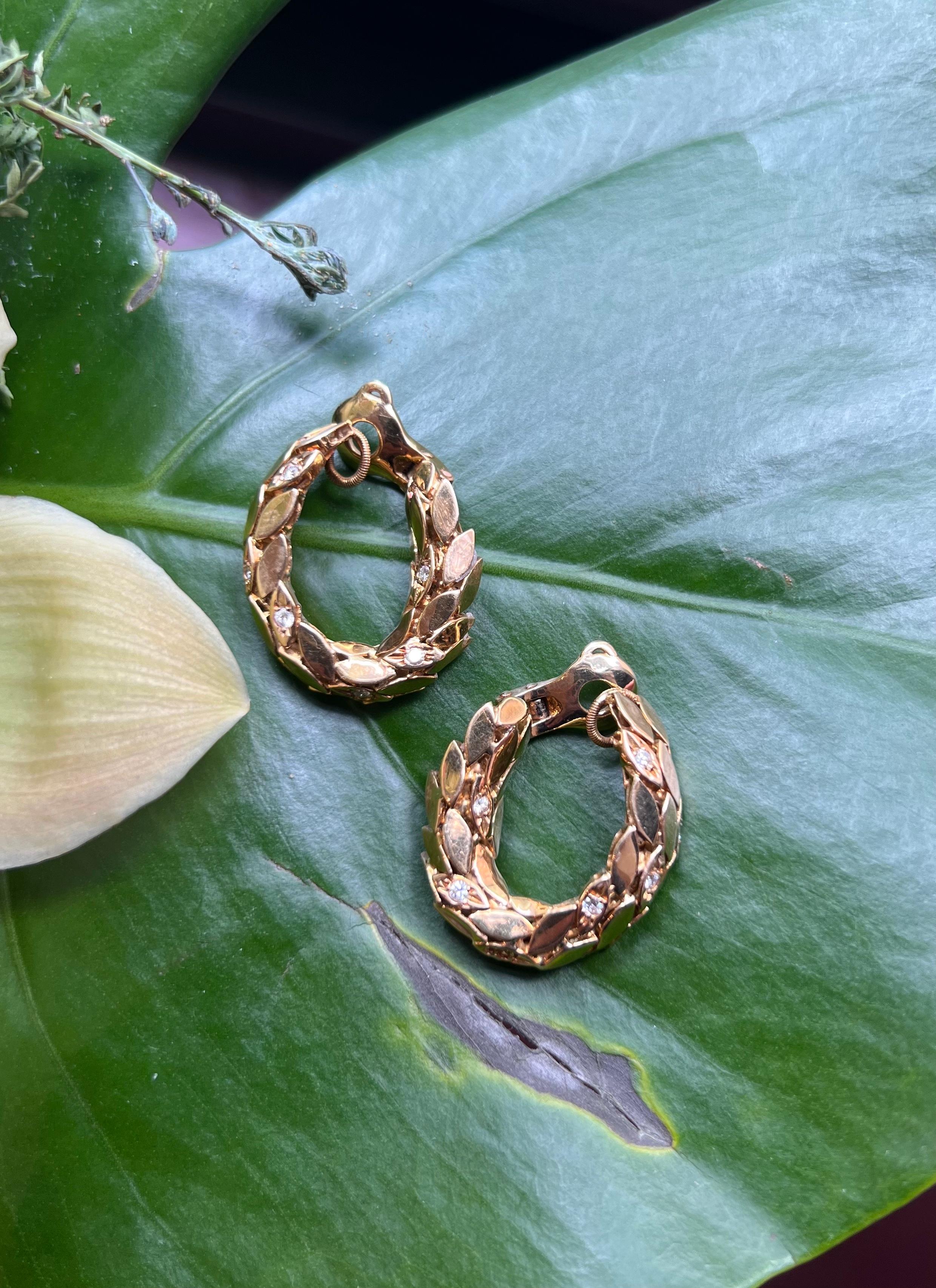 A pair of diamond and 18 karat yellow gold clip-on hoops, by Maison Gérard, circa 1970. These gold hoop earrings are of openwork foliate design, each comprised of multiple gold leaves set with approximately .50 carats of round brilliant-cut diamonds