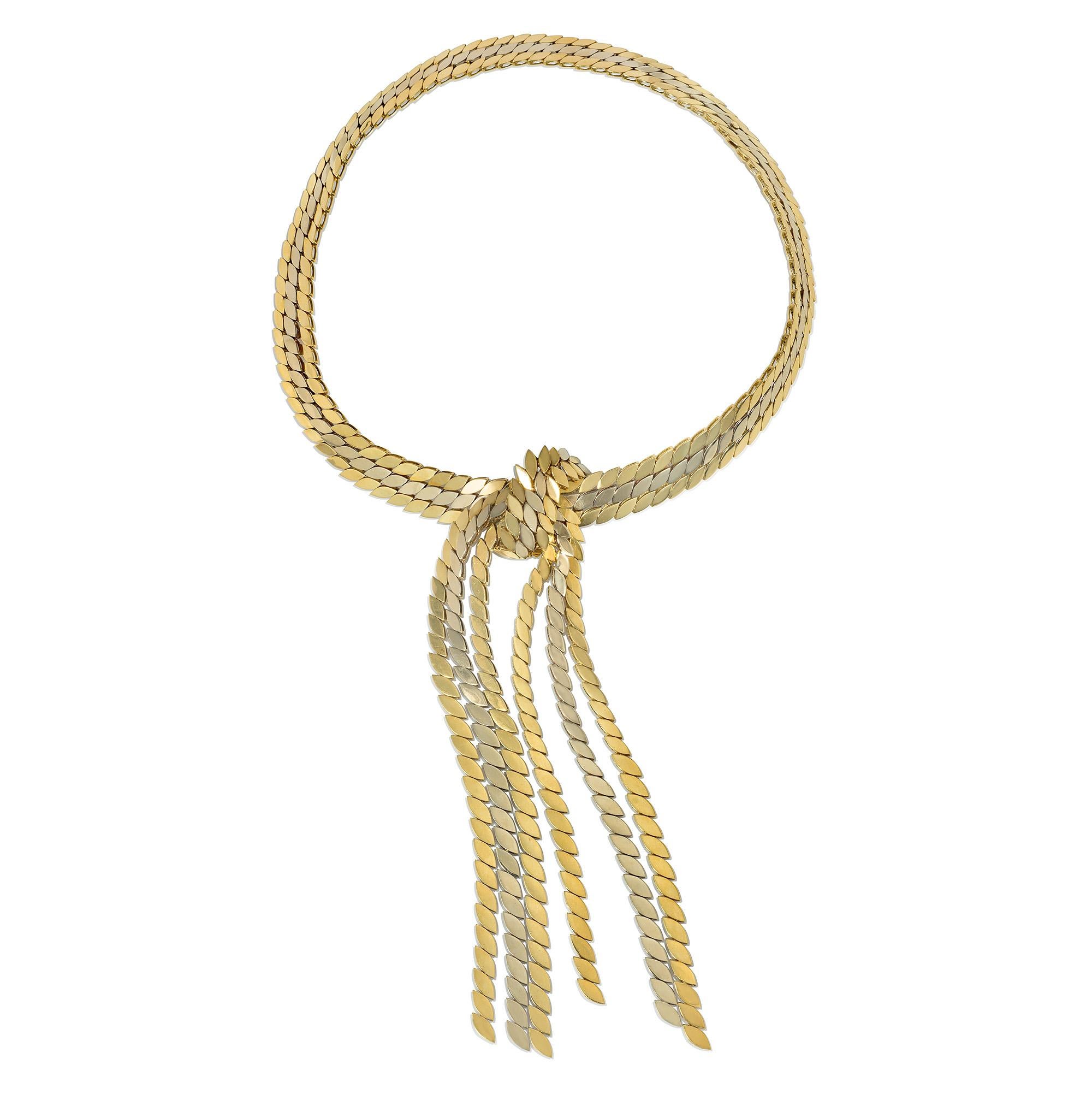 A two-color gold necklace comprising three rows of yellow and white gold navette-shaped links, with knotted center and long cascading tassel terminals, in 18k.  Maison Gerard, France.  #4648.

Dimensions: 16.5