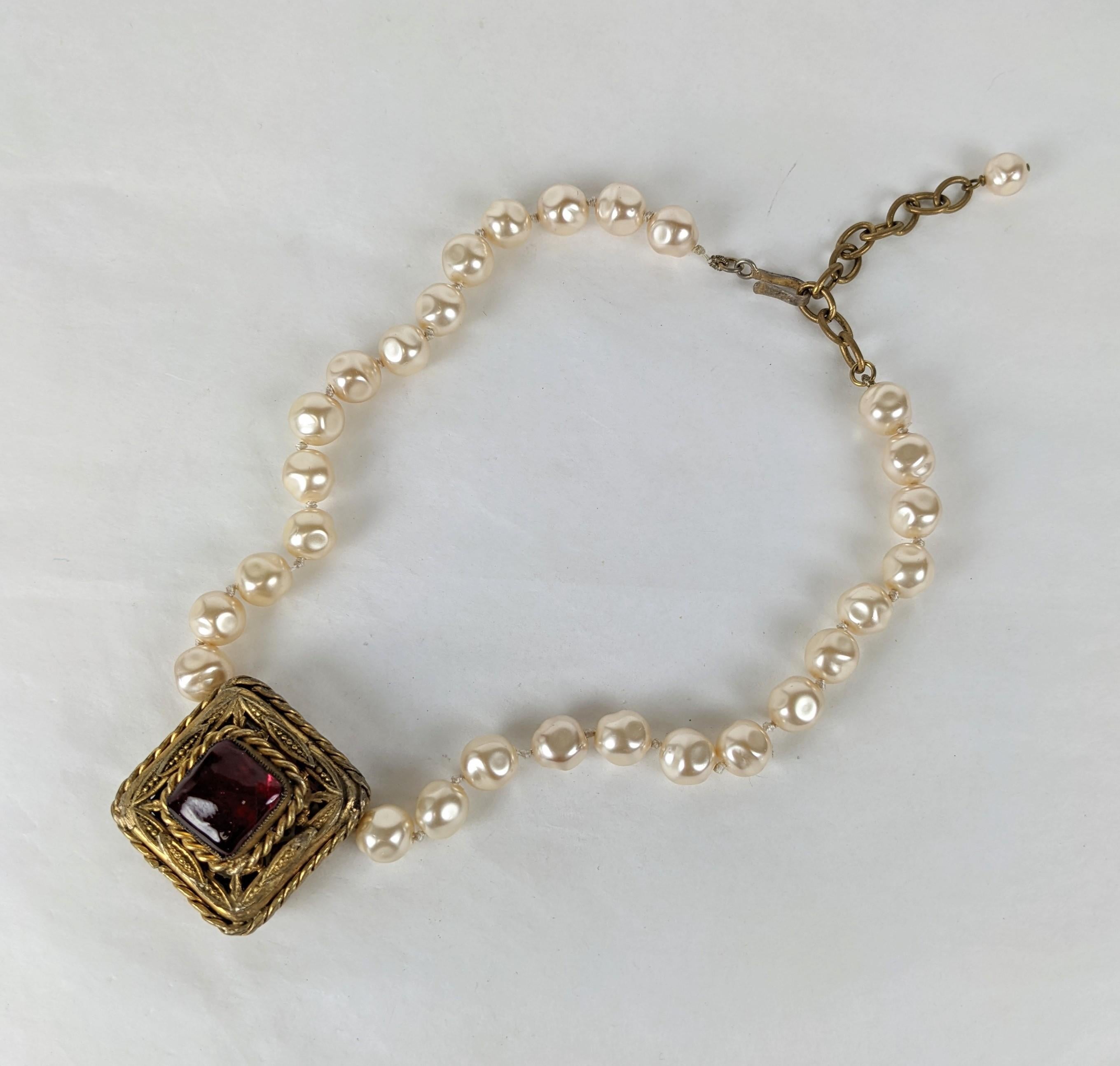 Karl Lagerfeld and Maison Gripoix for Chanel hand knotted faux baroque pearl, gilt bronze filigree square byzantine pendant with Gripoix glass poured enamel ruby cabocheon. Gilt chain and hook closure. Signed Chanel with date 1983. 
Length  17.50