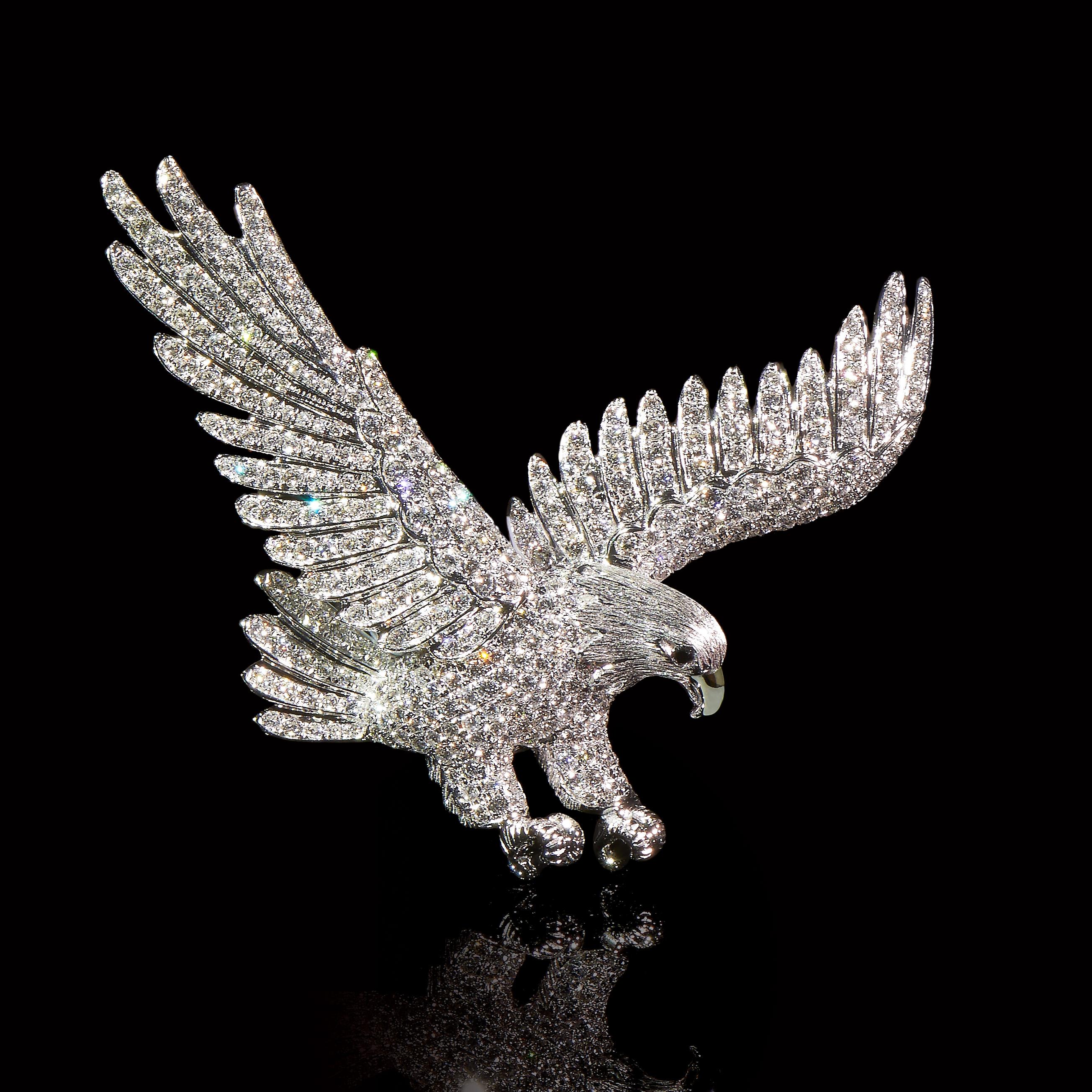 Dive  

2 Sapphires (0.026ct), 353 Diamonds (3.11cts), 18K White Gold.
Length: 55mm

An eagle with strong wings and legs diving down from mid-air, aims at its prey. Movement of the bird is captured in diamond and white gold.