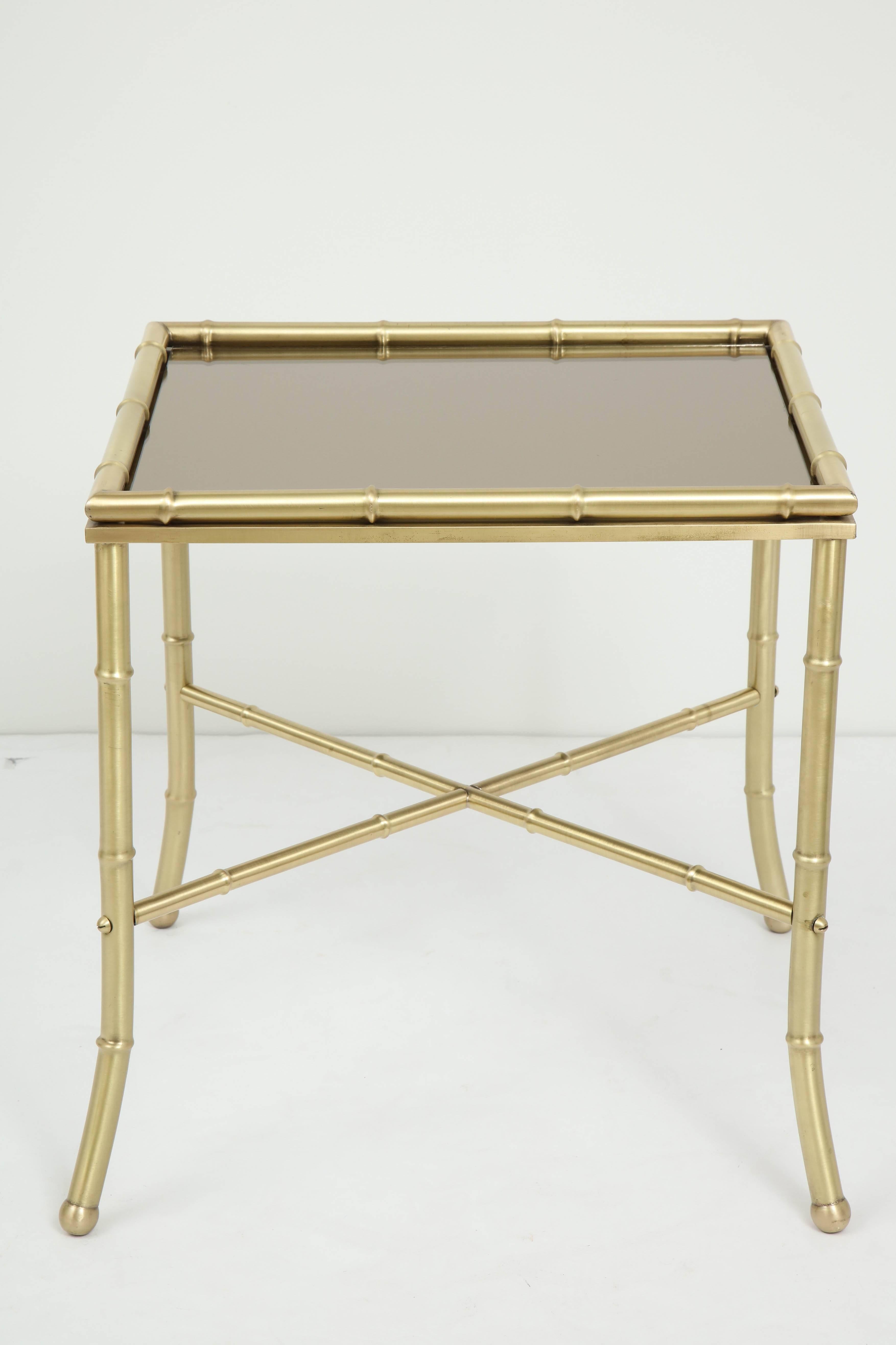 French 1960s stylized satin finished brass bamboo side tables with bronze mirror inset tops splayed legs and stretcher, style of Maison Jansen.