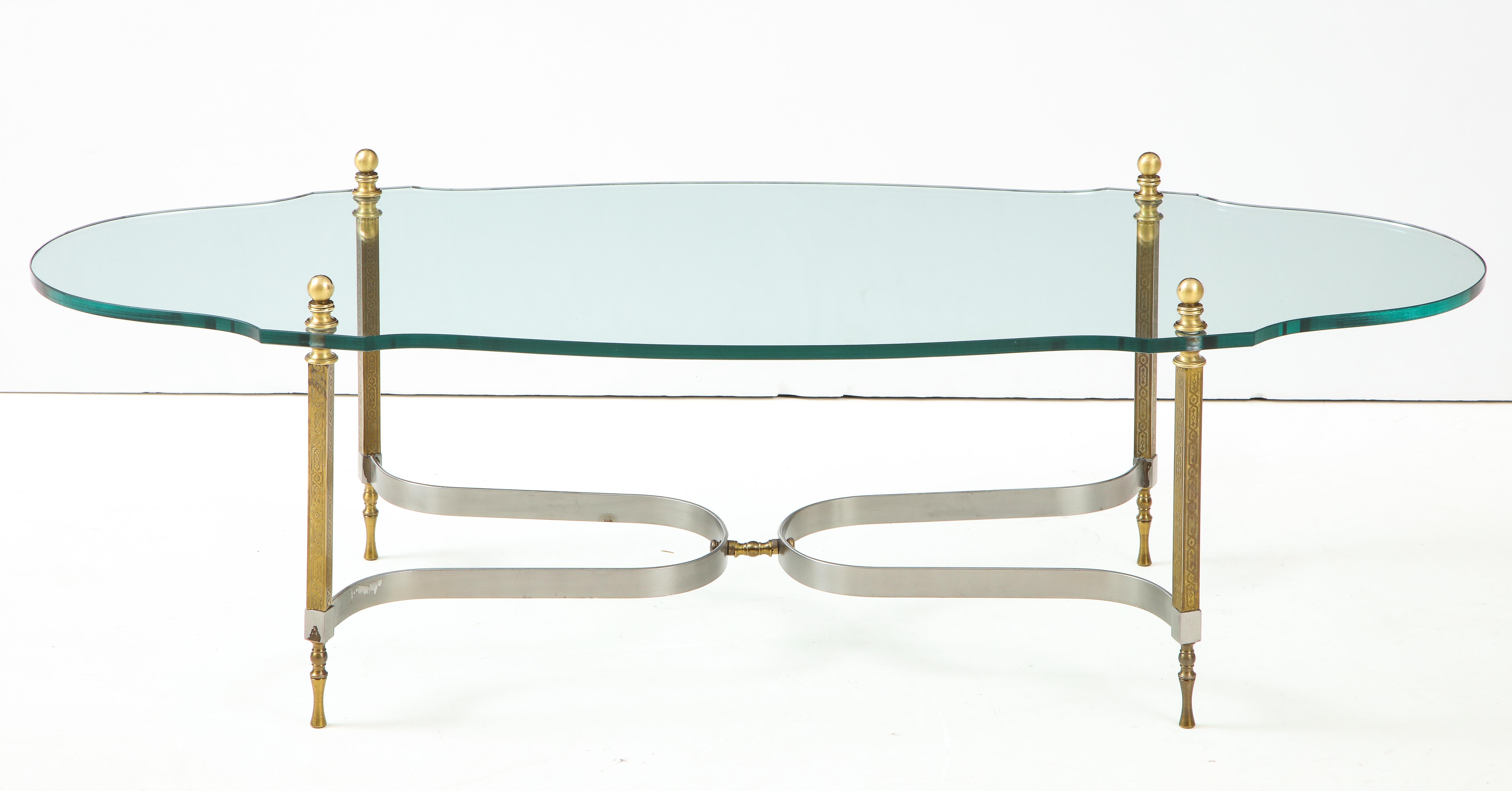 1960s modern brass and steel base with glass top coffee table attributed to Maison Jansen.