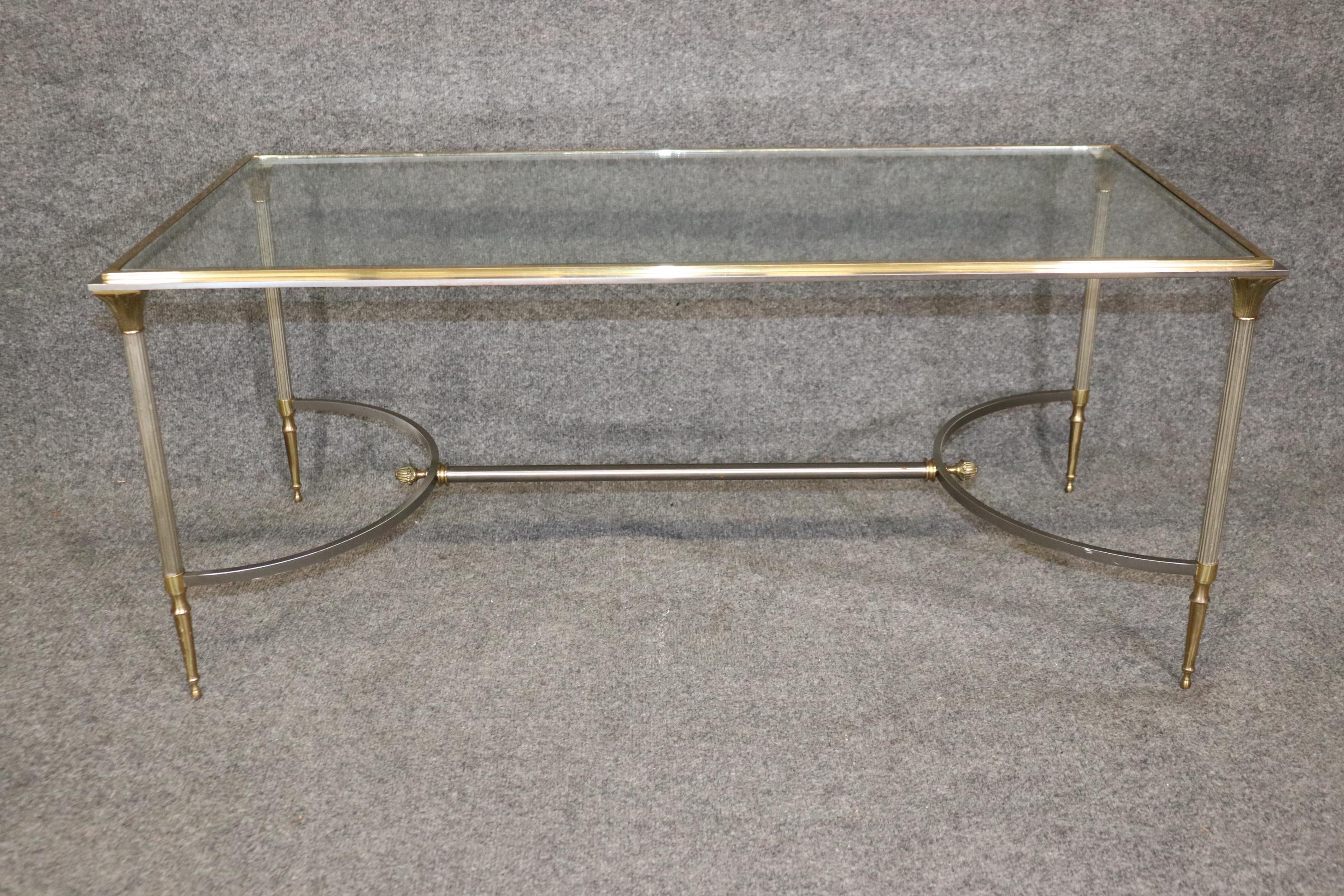 Dimensions: Height: 18 in Width: 42 in Depth: 20 in 

This Directoire style metal and brass glass top coffee table is of the highest quality! Maison Jansen made some of the world's most chic furniture and designed to replicate the earlier styles of