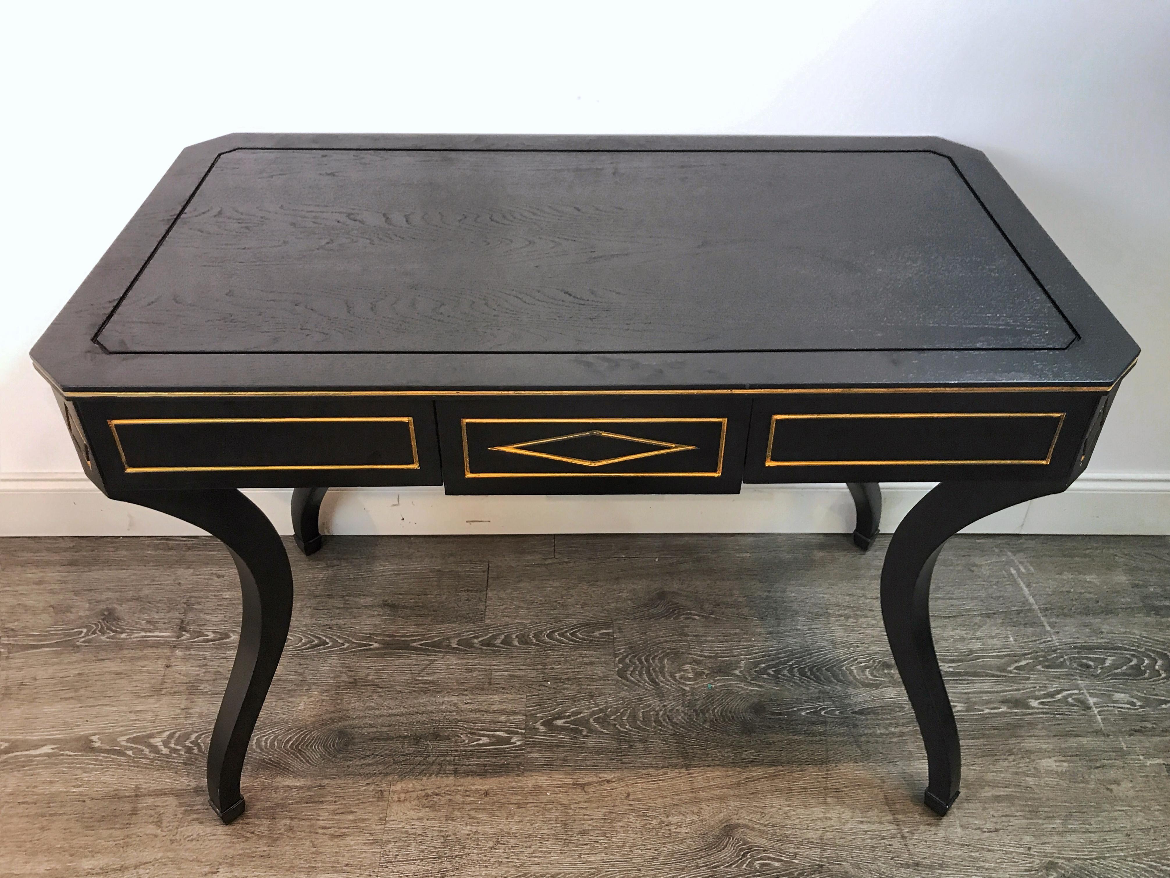 Maison Jansen (Attributed) black lacquered writing desk, of rectangular form with incised gilding, fitted with three frieze drawers, raised on shapely inverted legs. The flanking drawers both measure 14