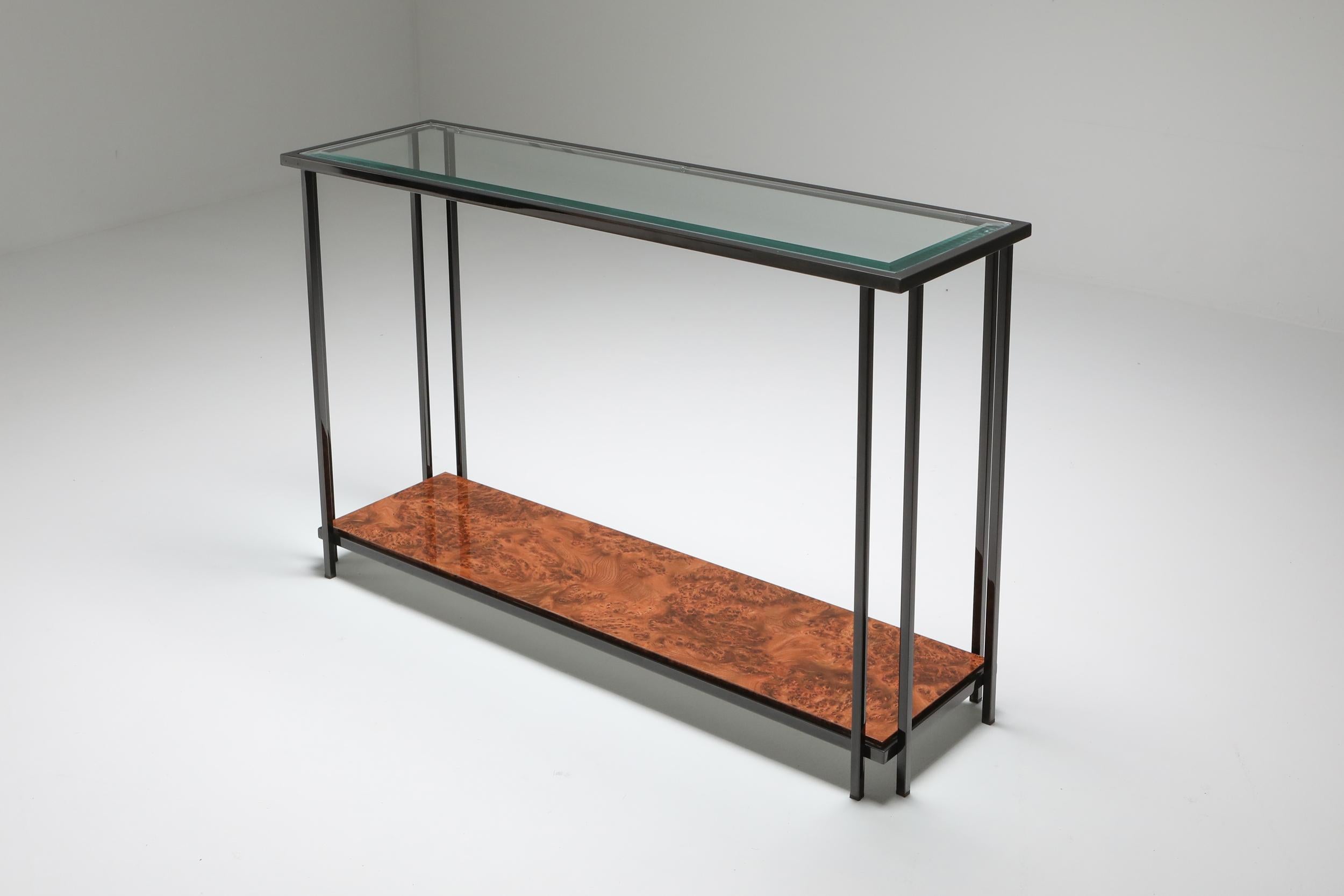 Postmodern Maison Jansen two-tier console table. Crafted in Belgium during the 1980s, this piece exudes timeless elegance and sophistication. Its sleek black patinated chromed steel frame provides a striking contrast to the luxurious burl laminate