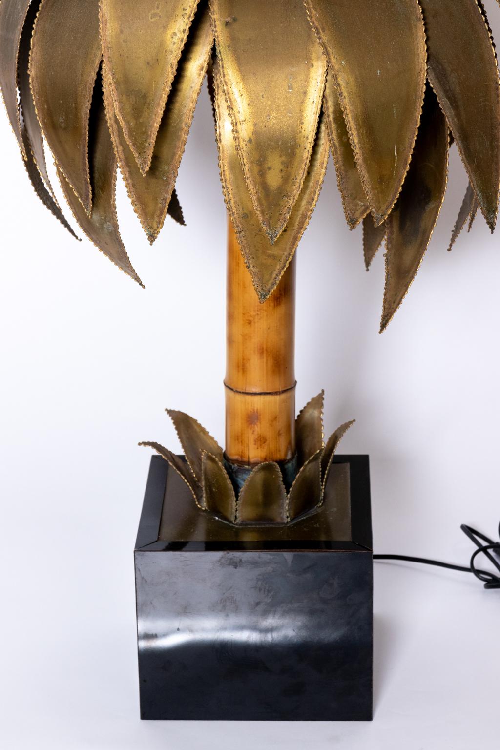 Circa 1970s brass and bamboo palm tree shaped lamp by Maison Jansen . This well known design features brass leaves with a bamboo trunk on a black base which can be also used as table centerpiece. Please note of wear consistent with age, the piece