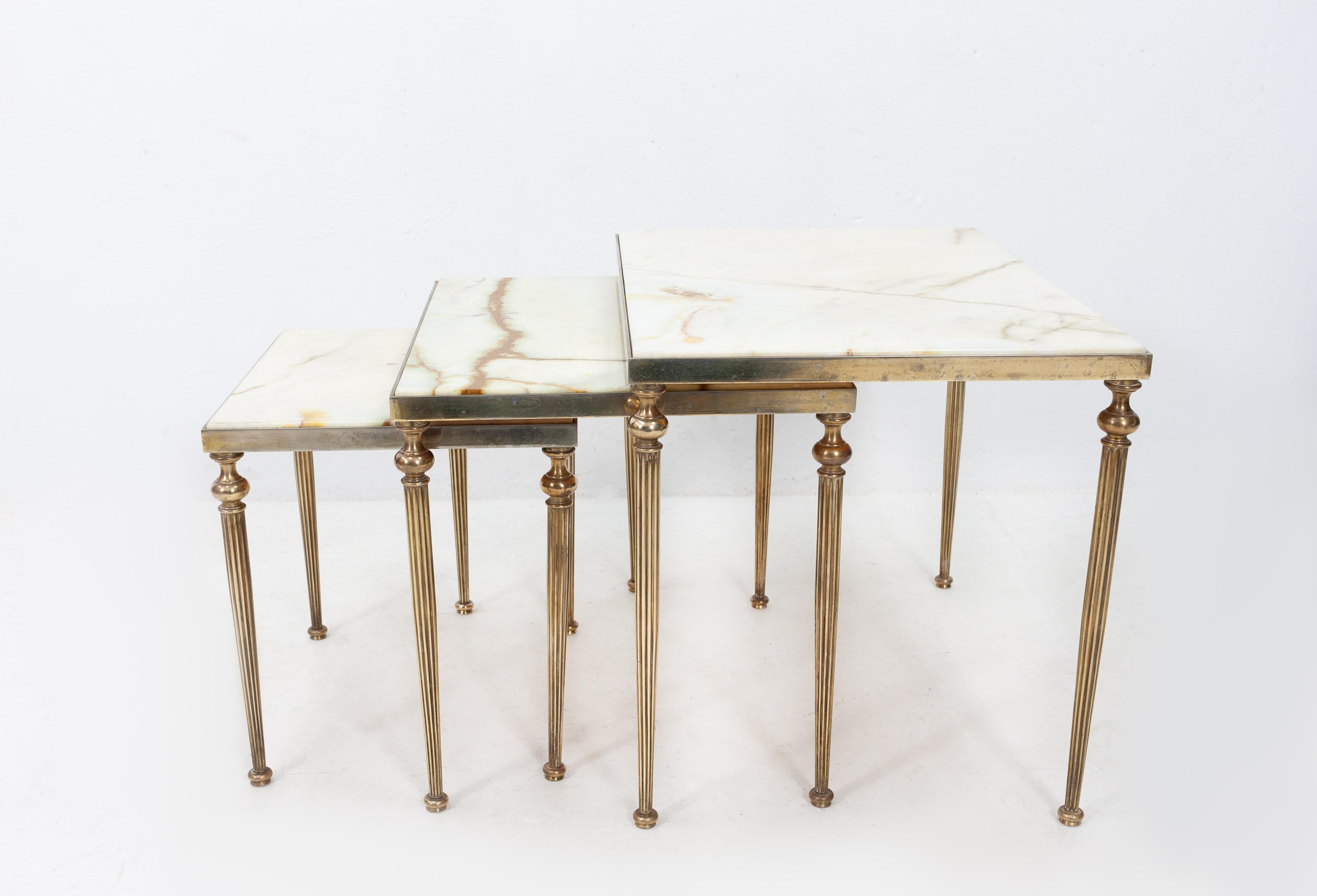 Maison Jansen brass nesting tables, comes with a thick white marble top. Very nice quality.
Solid brass base. Good looking and heavy set. Good condition. 1950s, Franc

Measures: Large height 42 cm, width 55 cm, depth 39 cm

Middle height 38 cm,