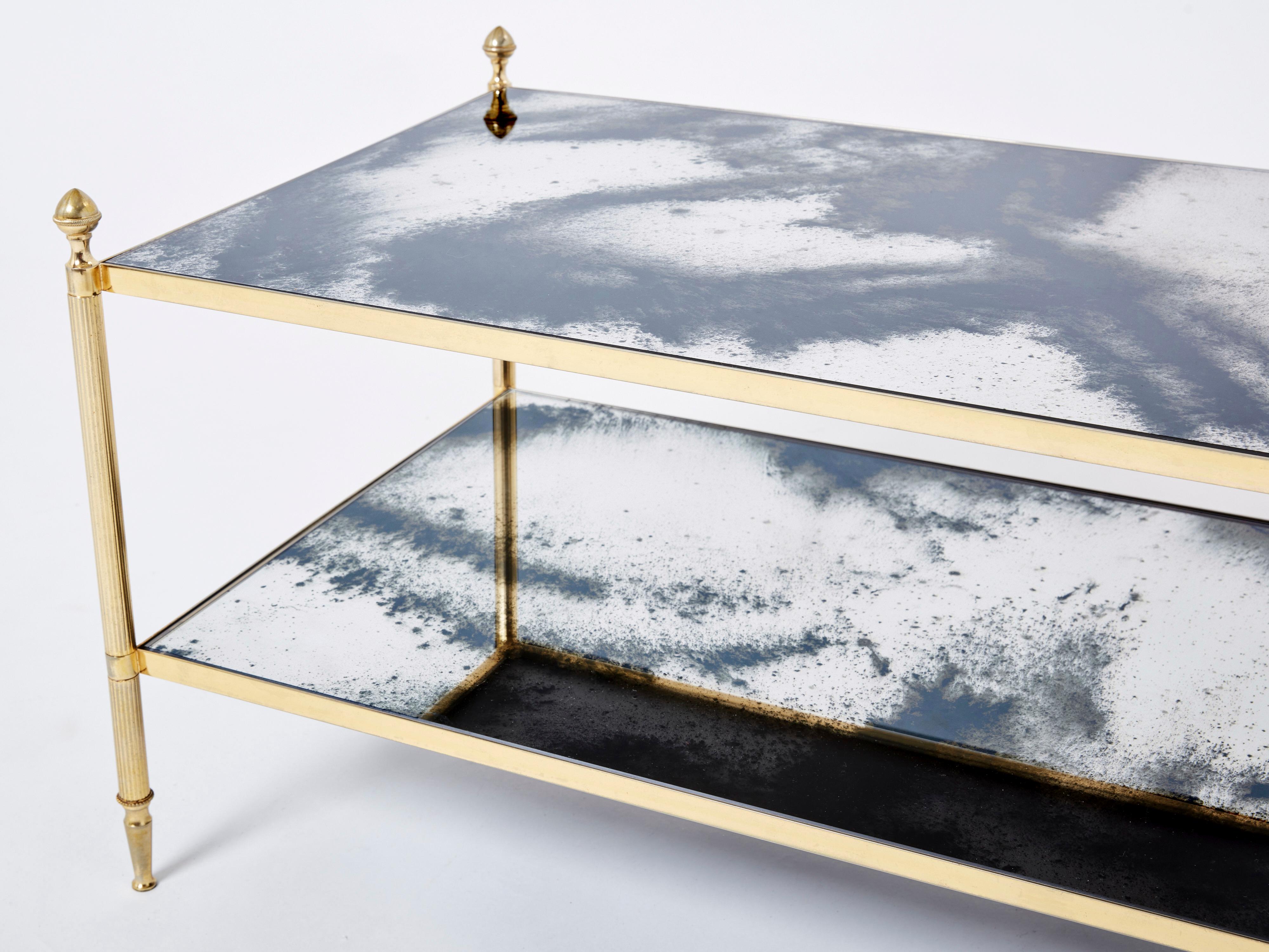This coffee table by French design house Maison Jansen was created with beautiful brass legs, chrome strappings, typical french neoclassical pine cones, and beautiful old patina mirrors in the 1970s. The two-tier mirrors are timeless and smooth,