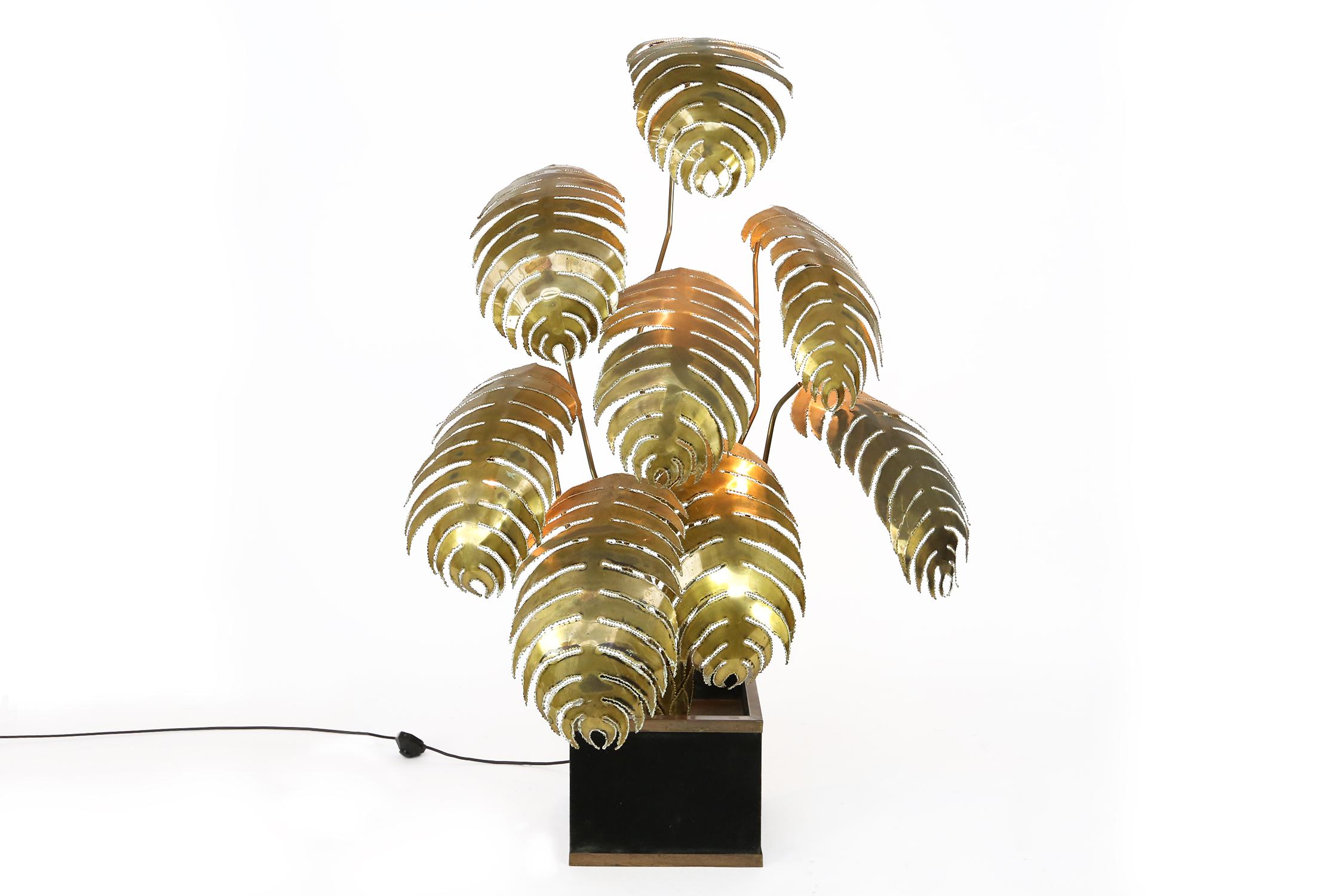 A rare and unique Maison Jansen flower floor lamp with eight brass leaves, 3 leaves have a central lightbulb (E14 screwfitting), on a brass and black felt covered base.