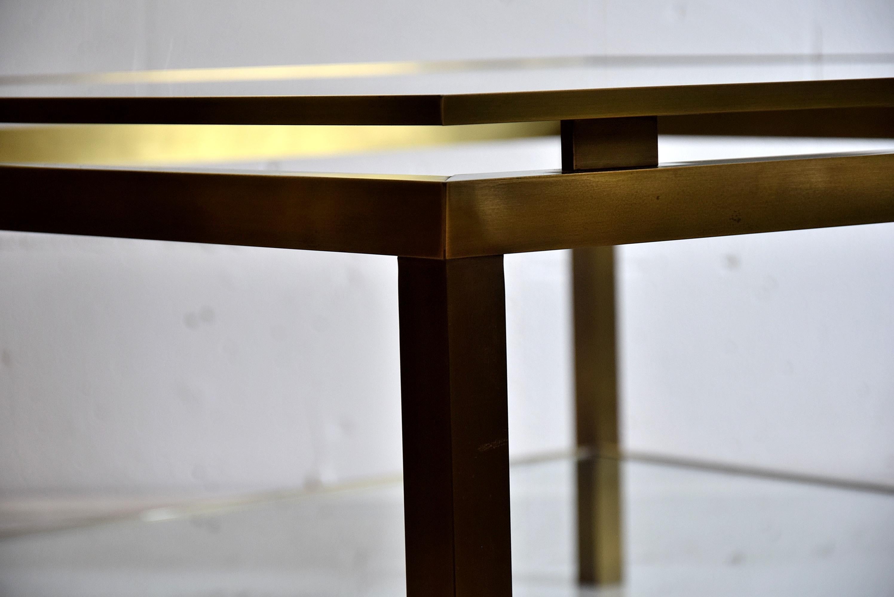 Sophisticated Hollywood Regency brass two tier coffee table in great condition and produced in France in the 1970s.
Both the glass top and bottom have a tiny chip of the glass in one of the corners as can be seen in the images.
The table will be