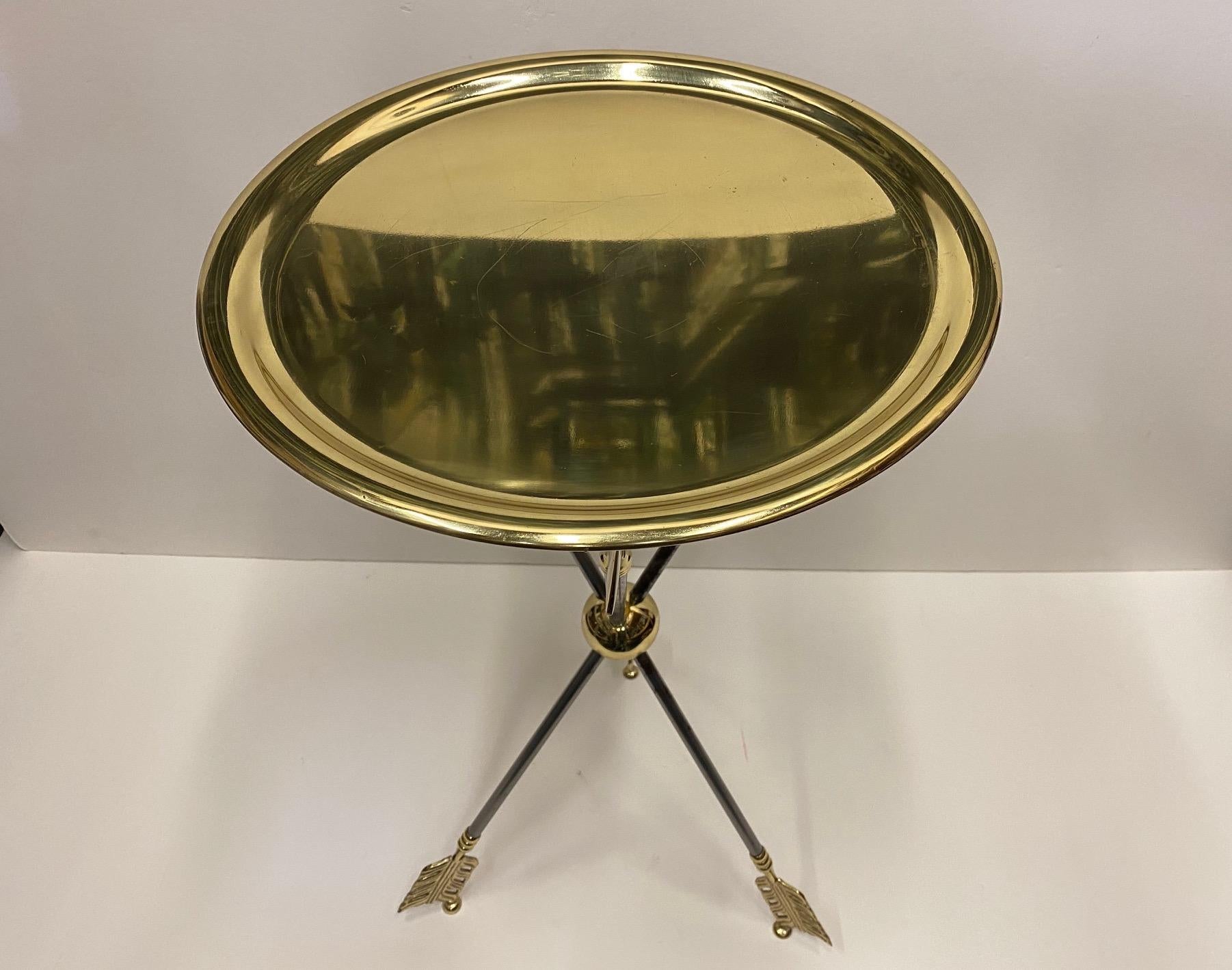 Very elegant Maison Jansen round end table having original brass trap top and superb brass and steel arrow motife base.