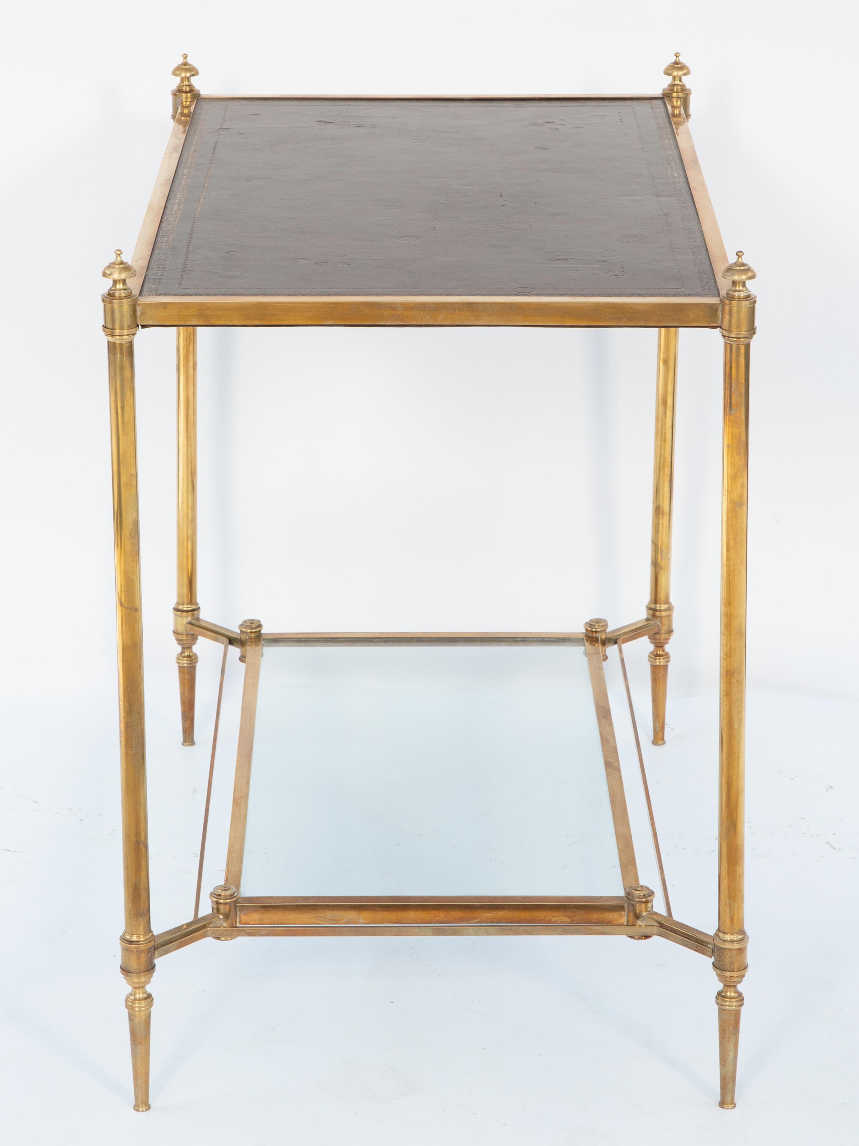 Mesa de té Maison Jansen de latón con tablero de cuero labrado y estante de cristal estirado mediados del siglo XX en venta