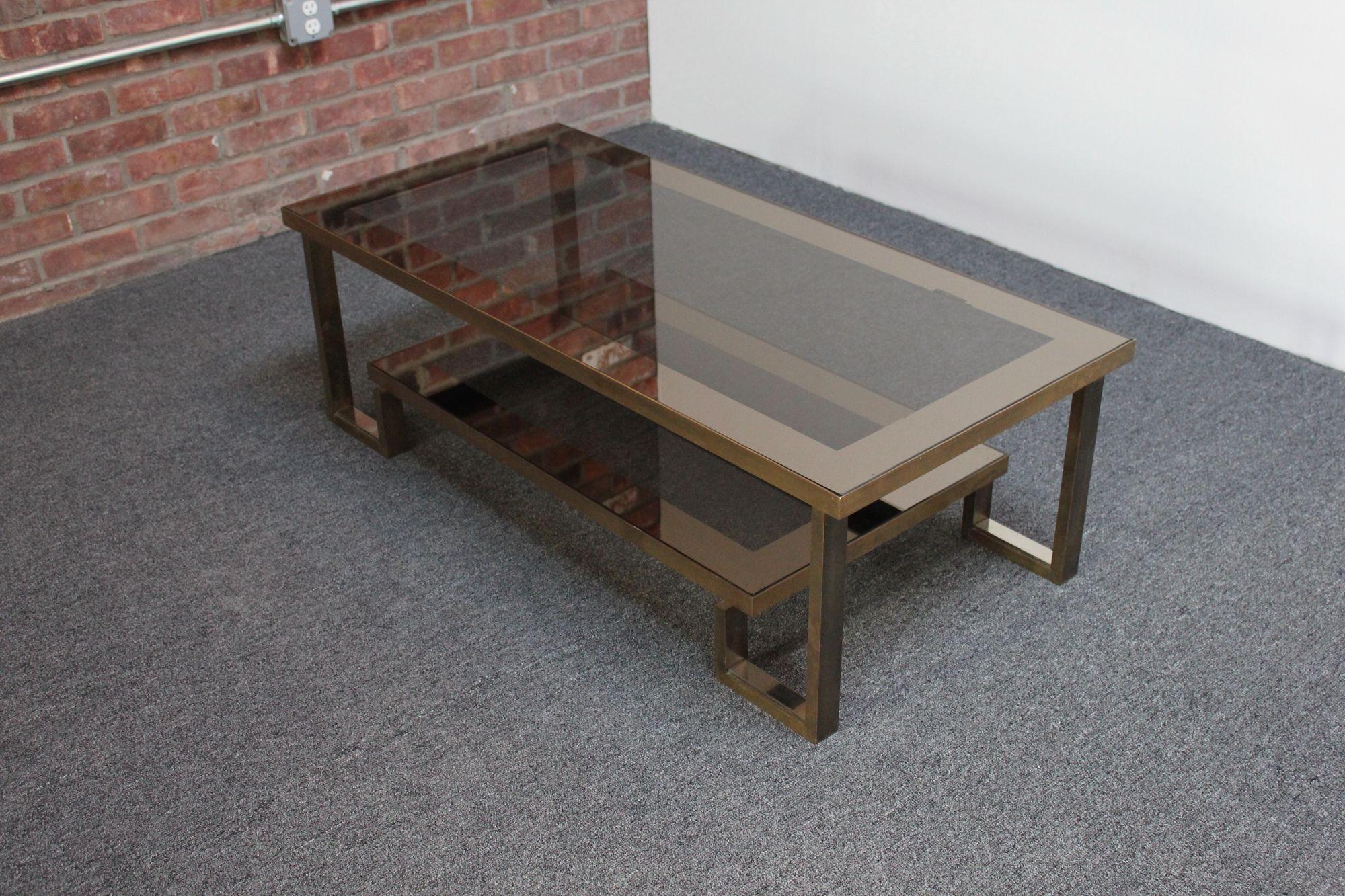 Luxurious, low Maison Jansen coffee table with bronze edging and smoked mirror glass surfaces (ca. 1960s, France).
Beautifully aged/all-original condition with patina to the bronze and mirror along with glass scuffs to the glass consistent with age