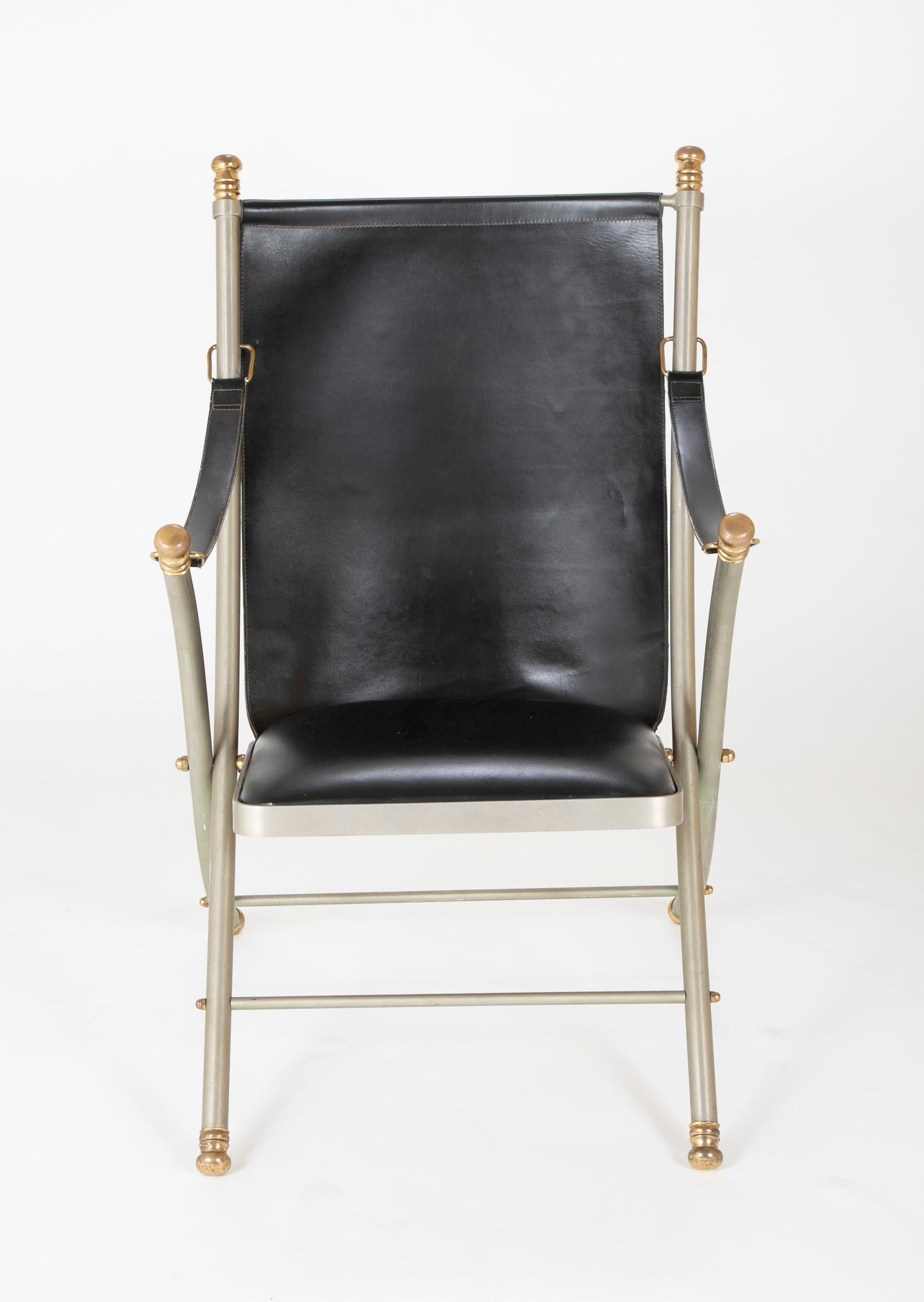 This is a rare model of a midcentury Maison Jansen campaign armchair. These chairs are typically made with paw feet, this example is unusual in that the knob feet match the finials on top, a thoroughly modern touch, possibly a custom order. Entirely