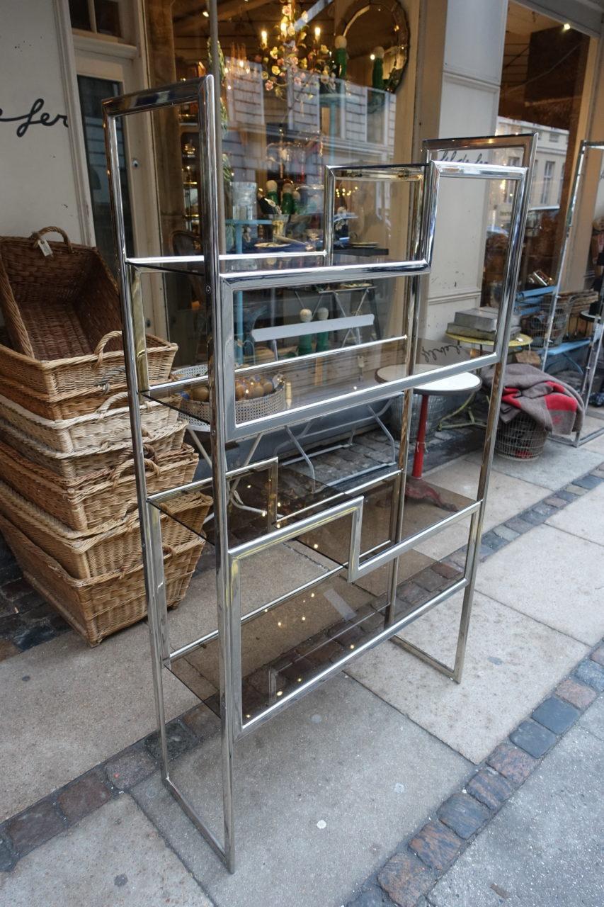 Sophisticated and gorgeous French shelves, from the legendary house for interior design Maison Jansen in Paris, circa 1970s this piece has an elegant profile of chrome framework and smokey glass shelves. Gorgeous practical shelving and size, whether