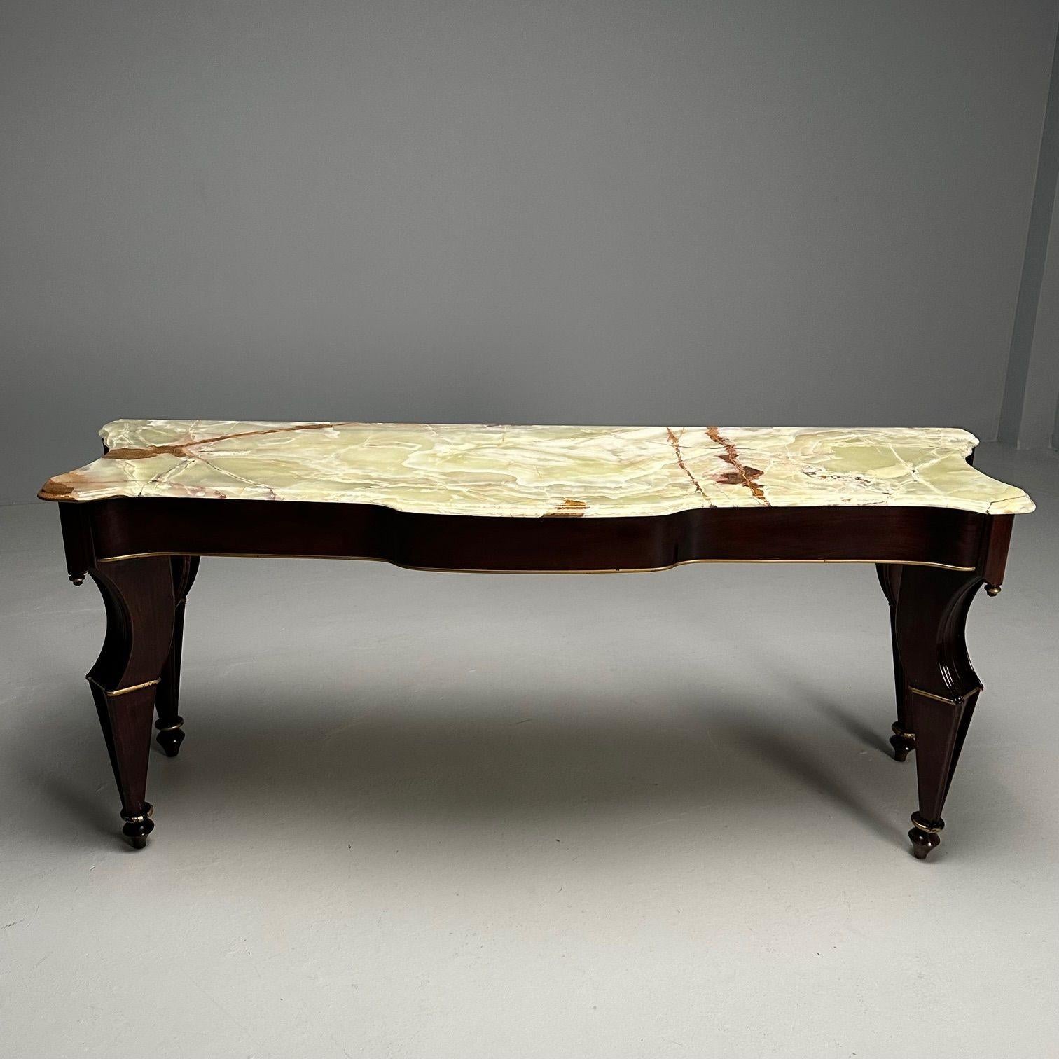 A grand French mahogany and parcel-gilt console table, circa 1940s, the shaped onyx marble atop a serpentine-shaped frieze, raised on four legs with fluted details. By Maison Jansen. Top having been professionally repaired many years ago. 