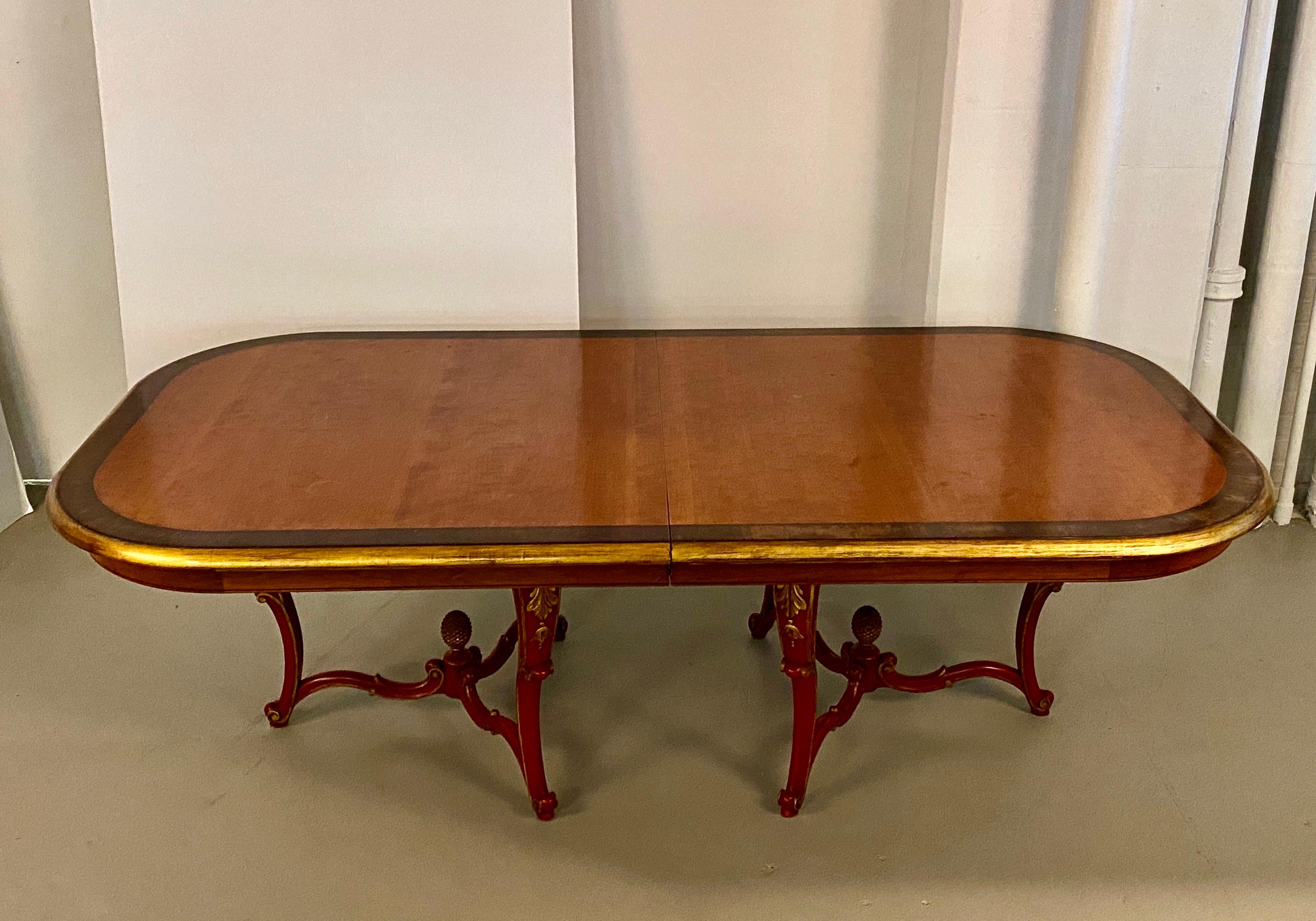 Note the lovely painted rococo base on this glamorous dining table. Deep cabriole legs in red and gold support a mahogany table top with lighter center and darker stained border. Fully extended with the leaf in place the table measures 9' 8