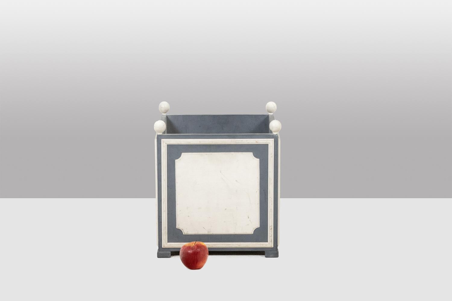 Maison Jansen, a cura di.

Fioriera in stile Direttorio in legno laccato bianco e grigio, che termina nella parte superiore con una decorazione di palline.

Opera francese realizzata negli anni '1970.

Dimensioni: H. 40,5 x L. 36 x P. 36