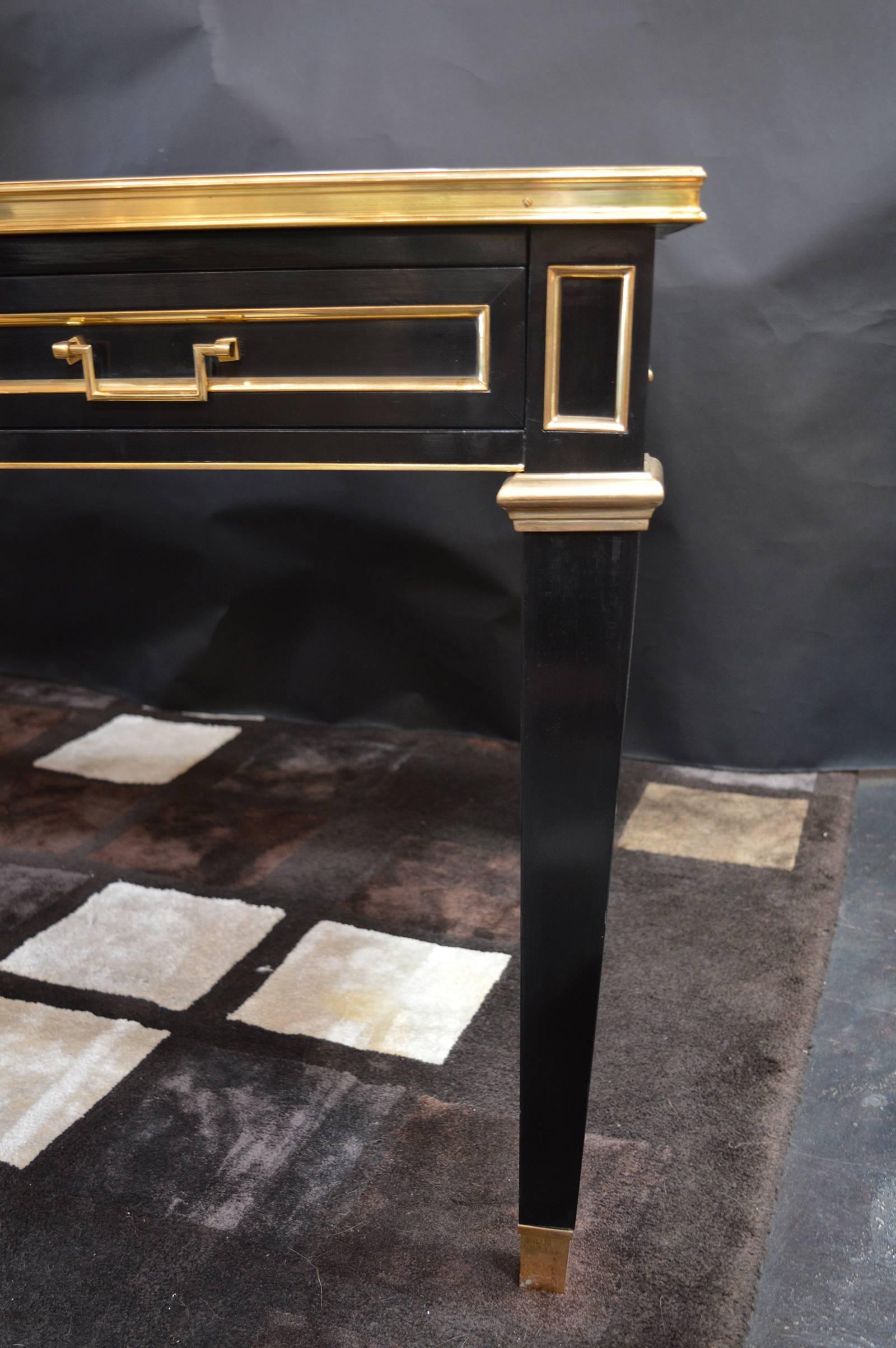 Louis XVI style ebonized bureau plat having inset leather top with bronze trim over drawers and supported on bronze mounted legs.
From Jansen collections, launched in 1972
Four drawers.