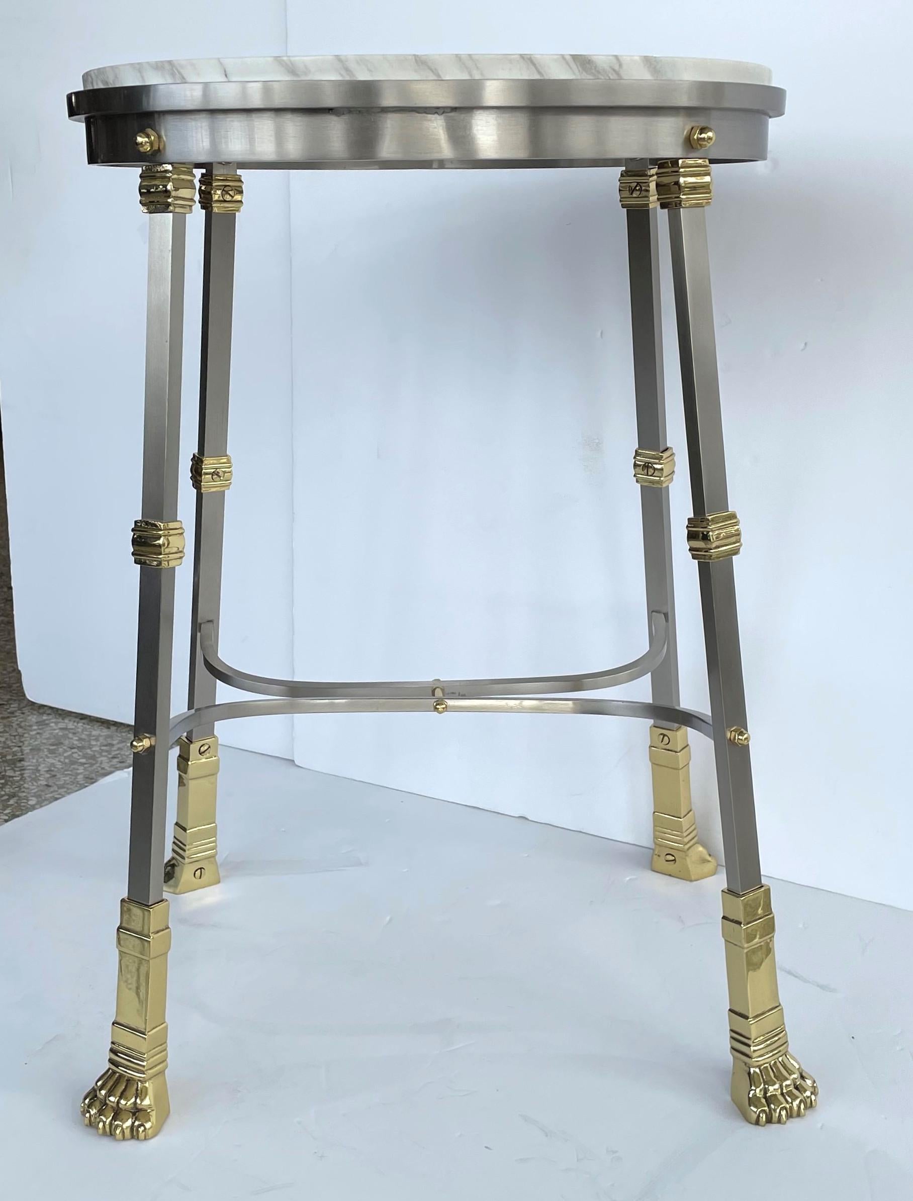 This stylish and chic oval-form, French empire revival side table dates to the 1960s-1970s and it has been professionally polished and finished with a clear lacquer (thus no tarnishing).